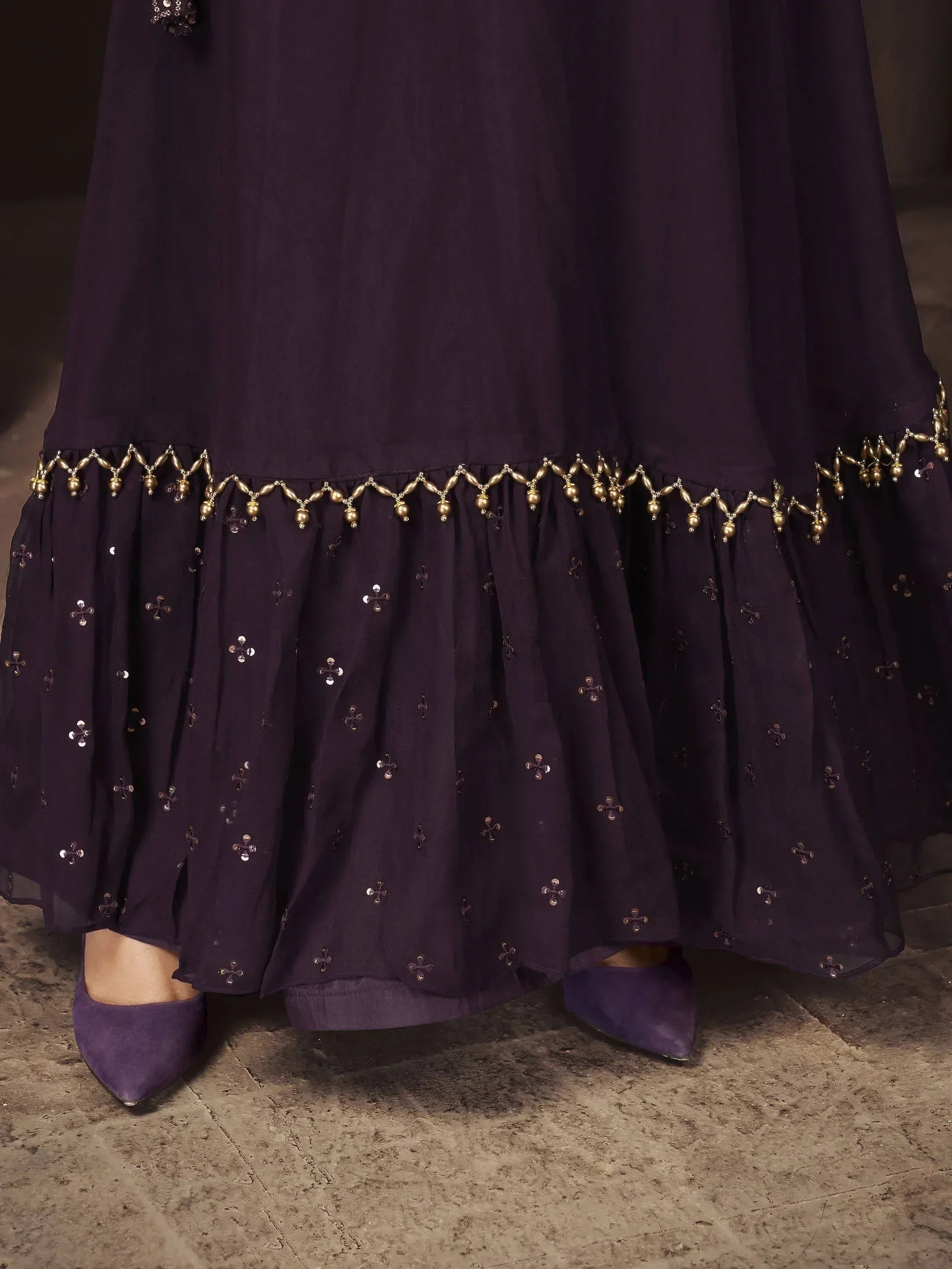 Purple ethnic gown with gold bead trim and sequin embroidery, paired with matching heels