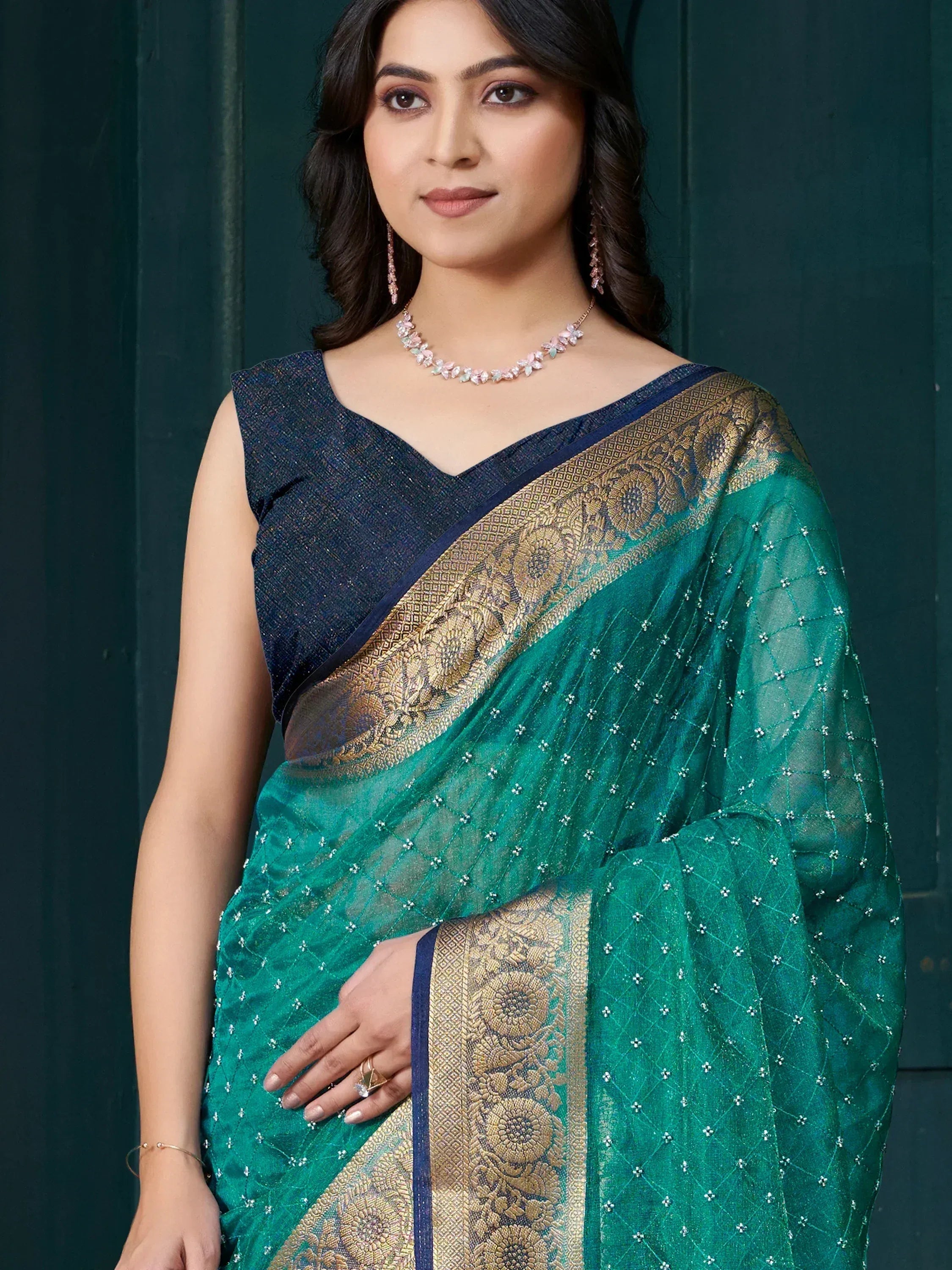 Emerald green saree with gold floral border and navy blouse, perfect for ethnic occasions