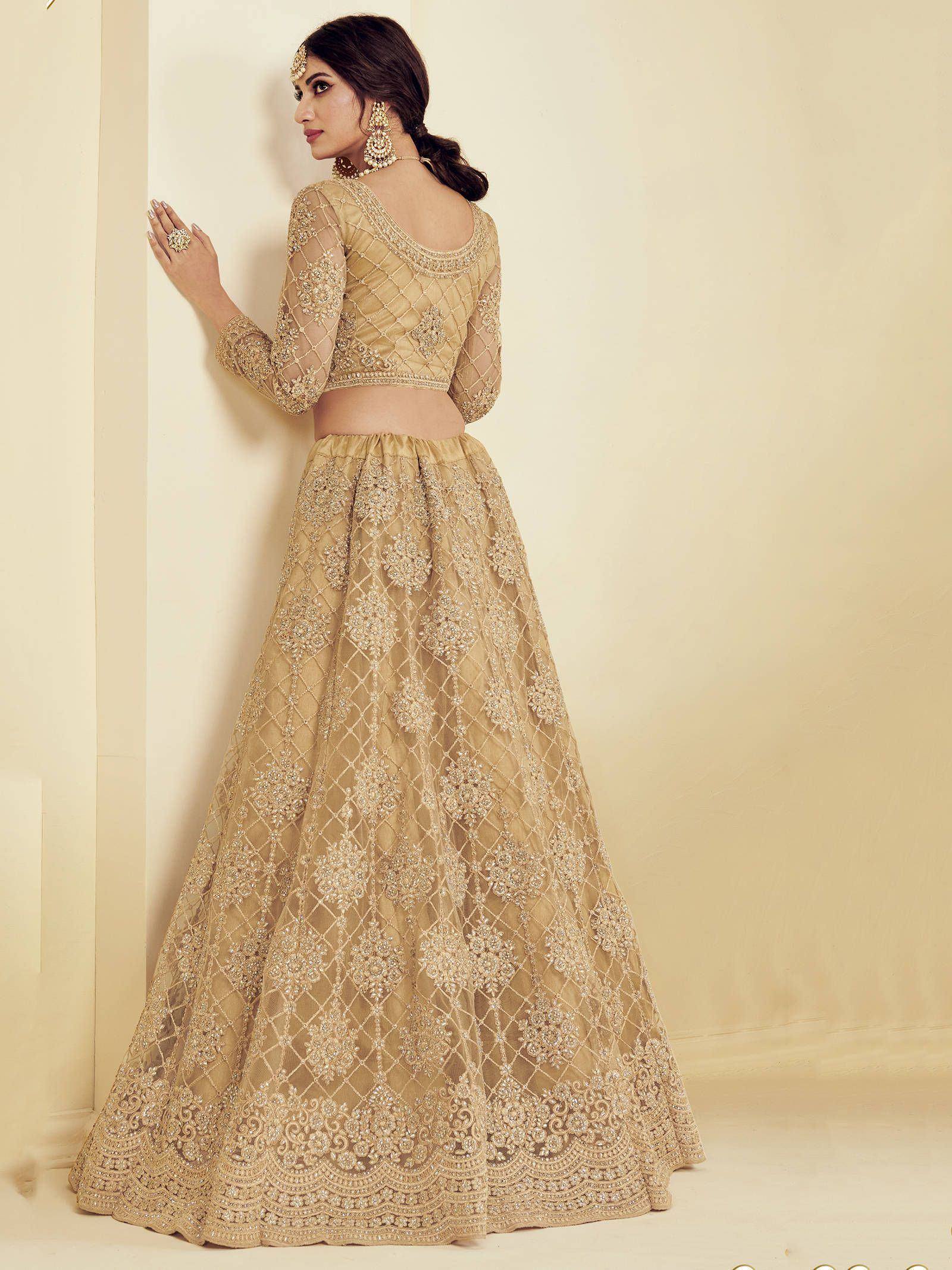 Elegant gold embroidered lehenga choli with sheer sleeves, perfect for Indian weddings and festive occasions.
