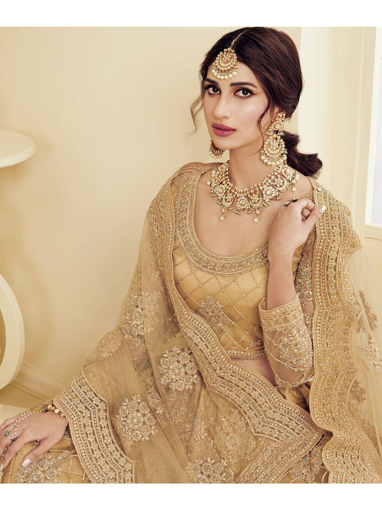 Elegant gold embroidered lehenga choli with matching jewelry for Indian ethnic wear