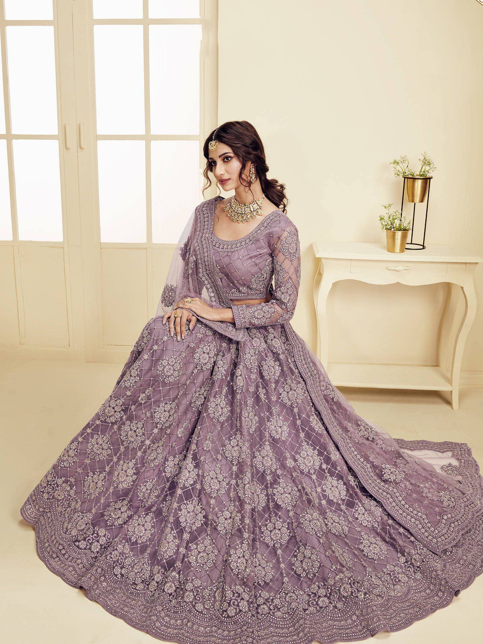 Lavender designer lehenga choli with intricate embroidery and net dupatta, perfect for Indian weddings and festive occasions.