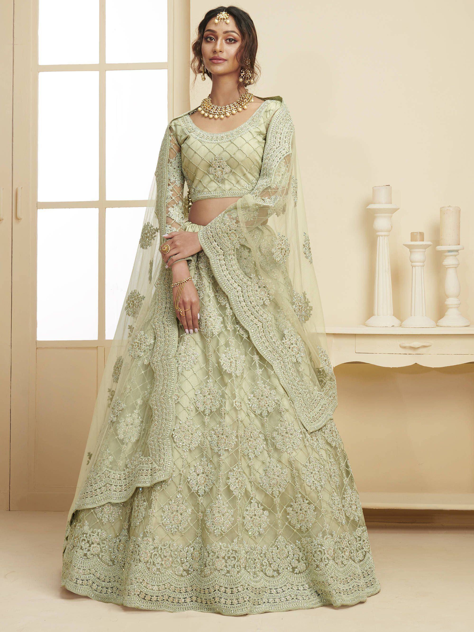 Elegant light green designer lehenga choli with intricate embroidery and sheer dupatta, perfect for Indian weddings.