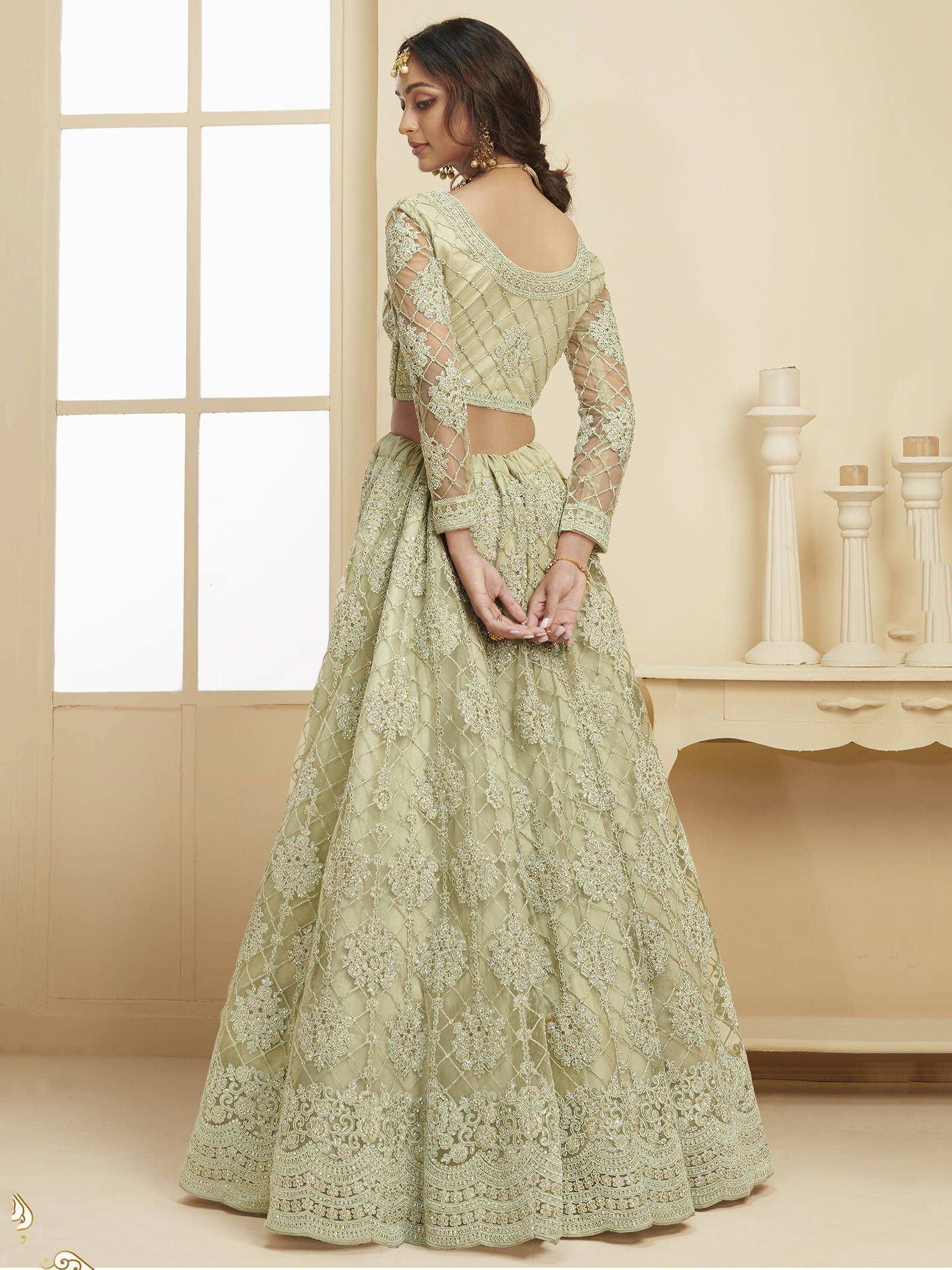 Elegant light green designer lehenga choli with intricate embroidery and sheer sleeves, perfect for weddings and festive occasions.