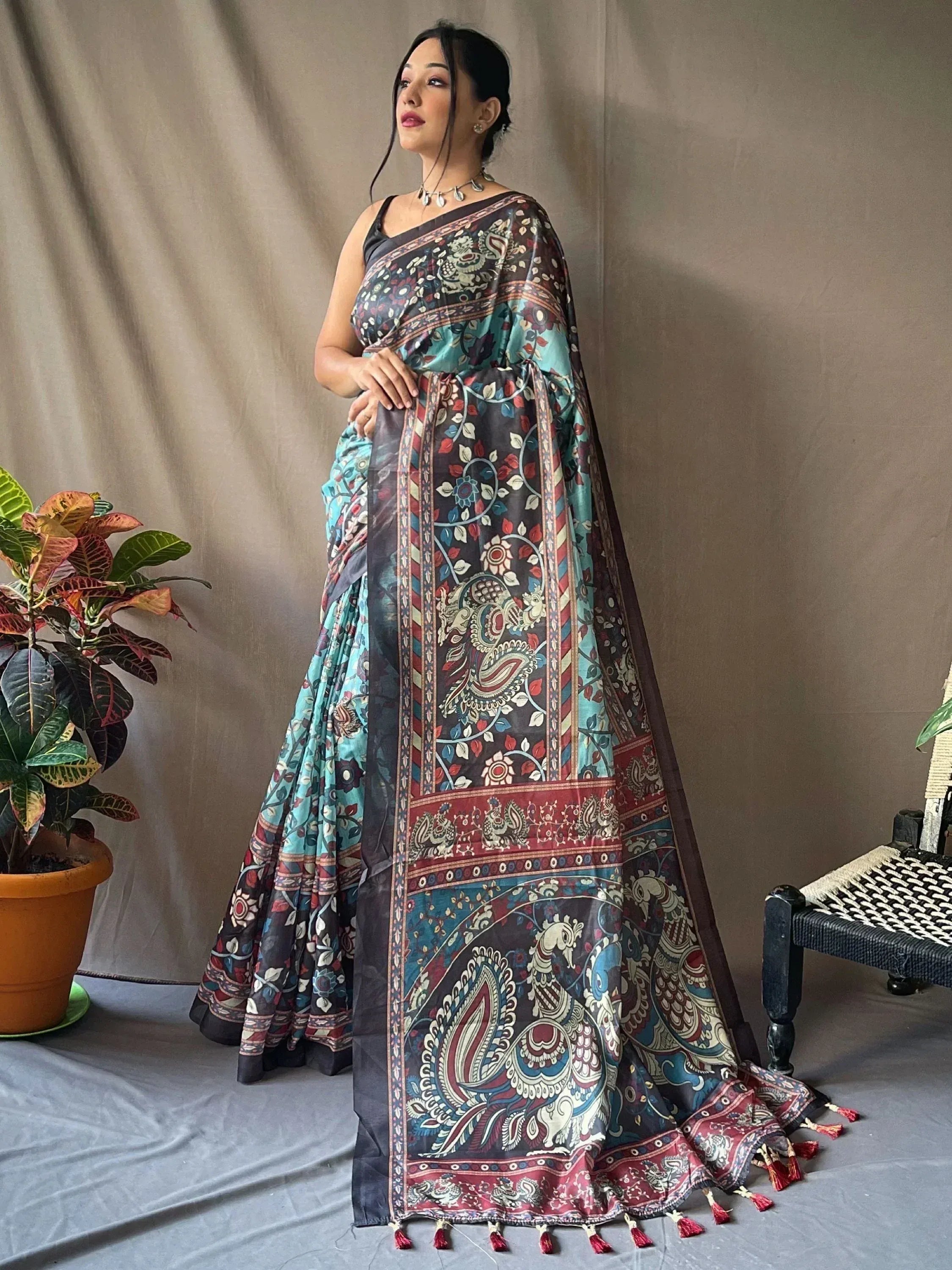 Woman in elegant Indian saree with paisley floral print, tassels, and contrast border for ethnic wear