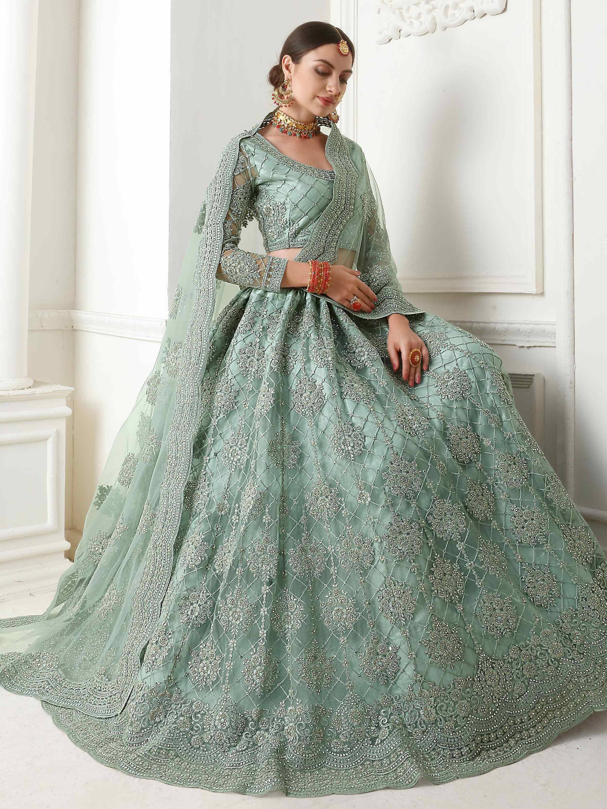 Mint green designer lehenga choli with heavy silver embroidery and sheer dupatta, perfect for Indian weddings.