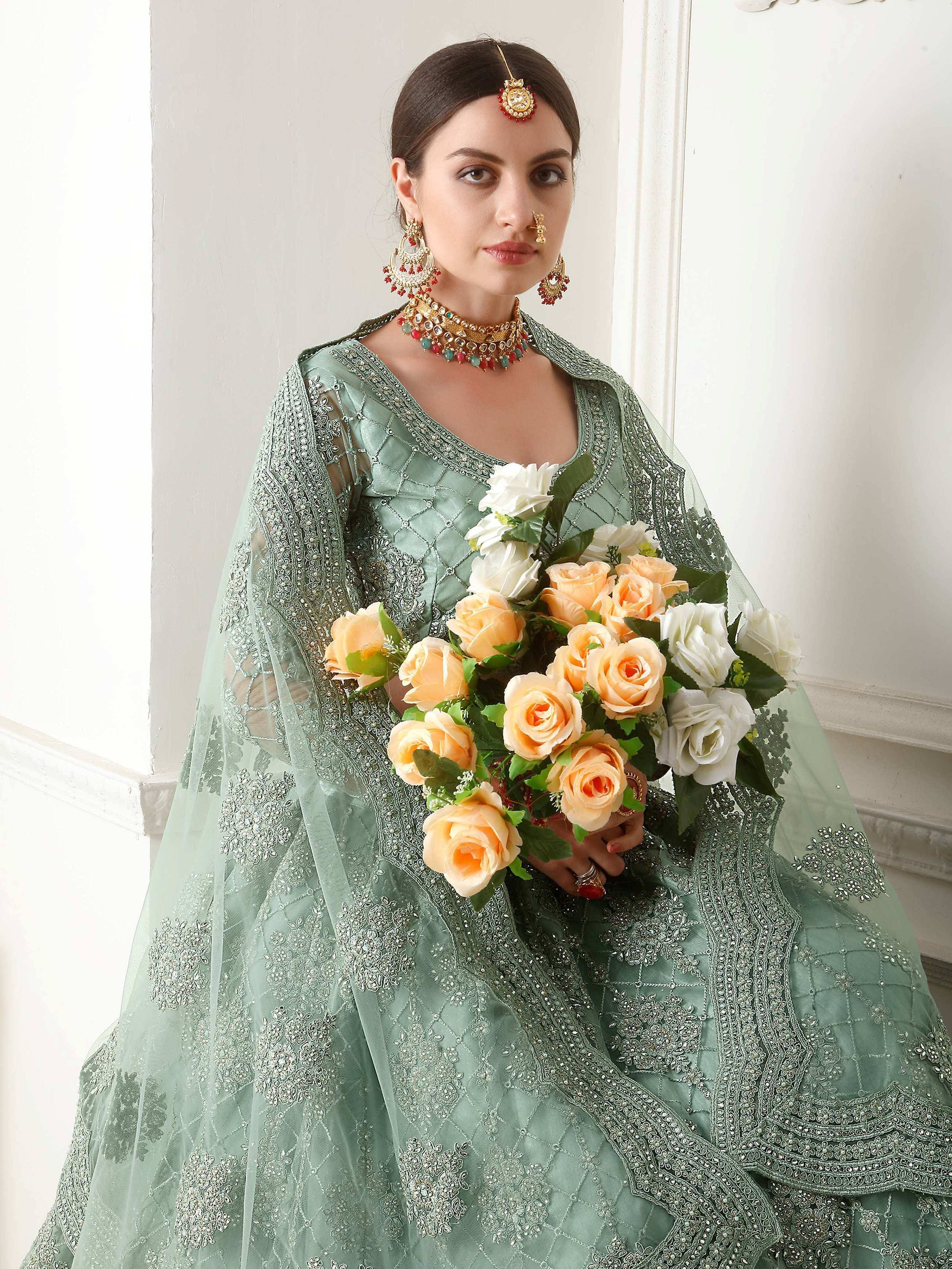 Mint green embroidered lehenga choli with floral bouquet, traditional Indian bridal wear