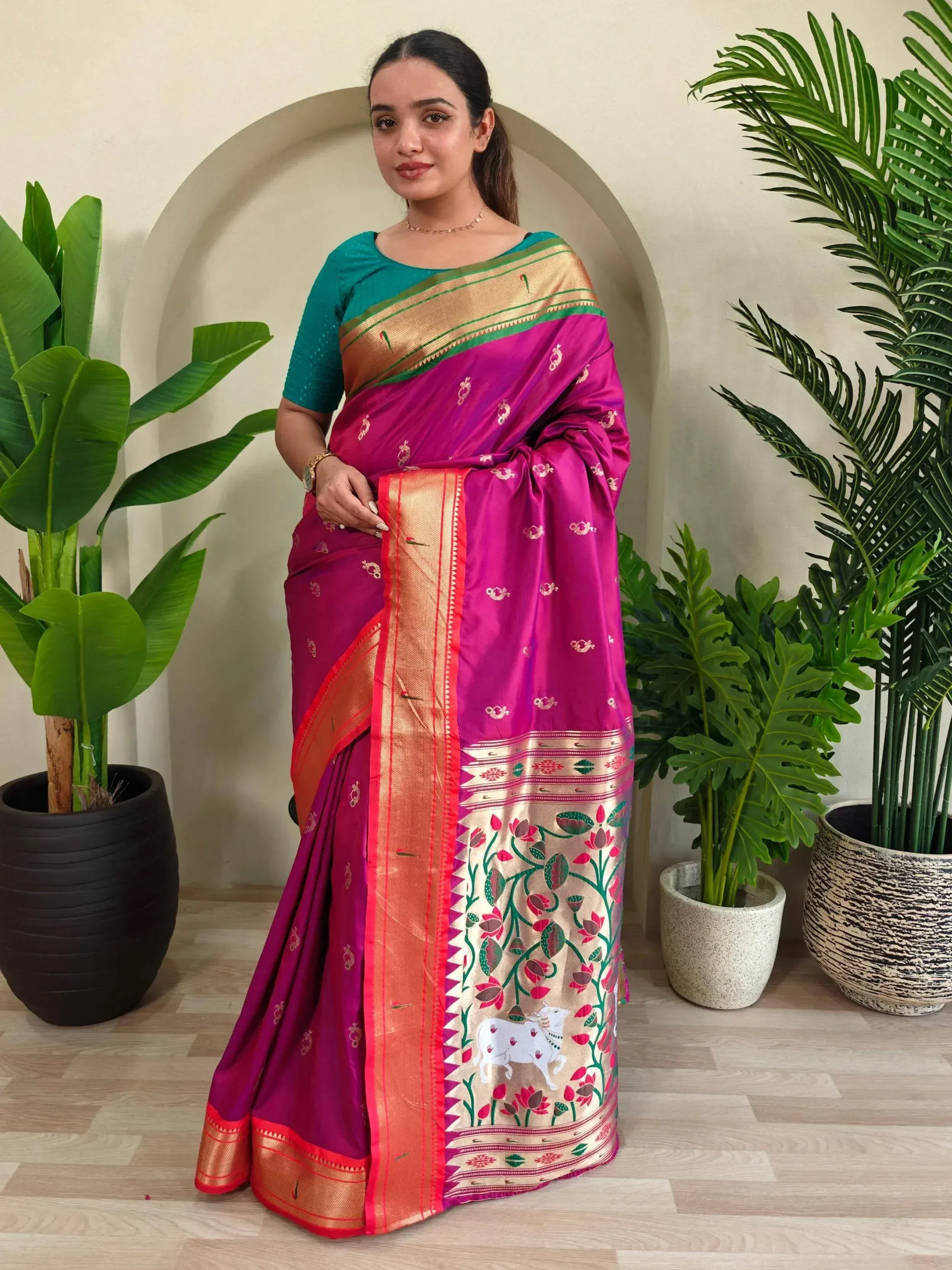 Vibrant magenta saree with gold border and floral motifs, paired with teal blouse, ideal for Indian ethnic occasions