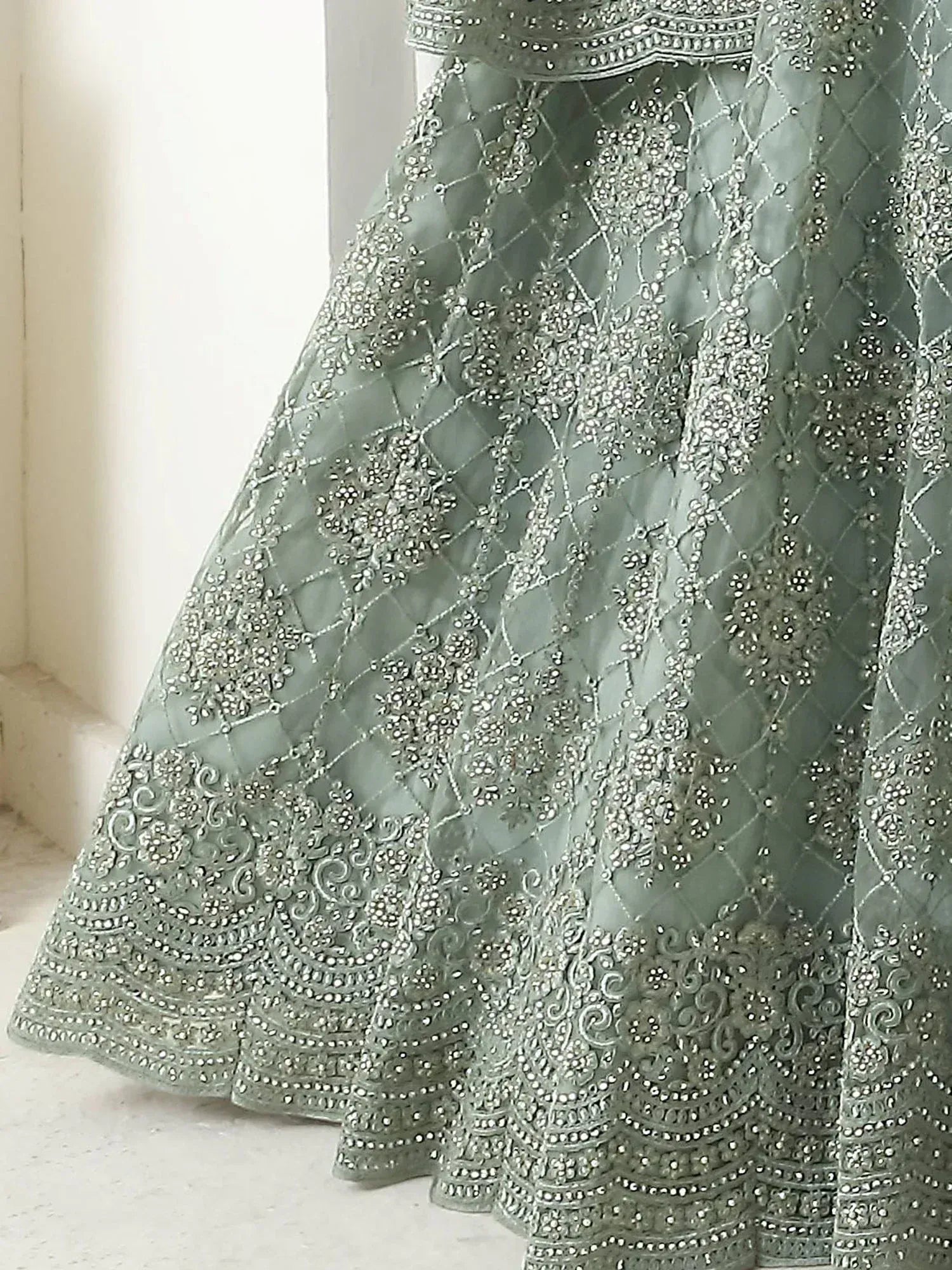 Mint green lehenga with intricate silver embroidery and floral motifs, perfect for Indian ethnic wear.