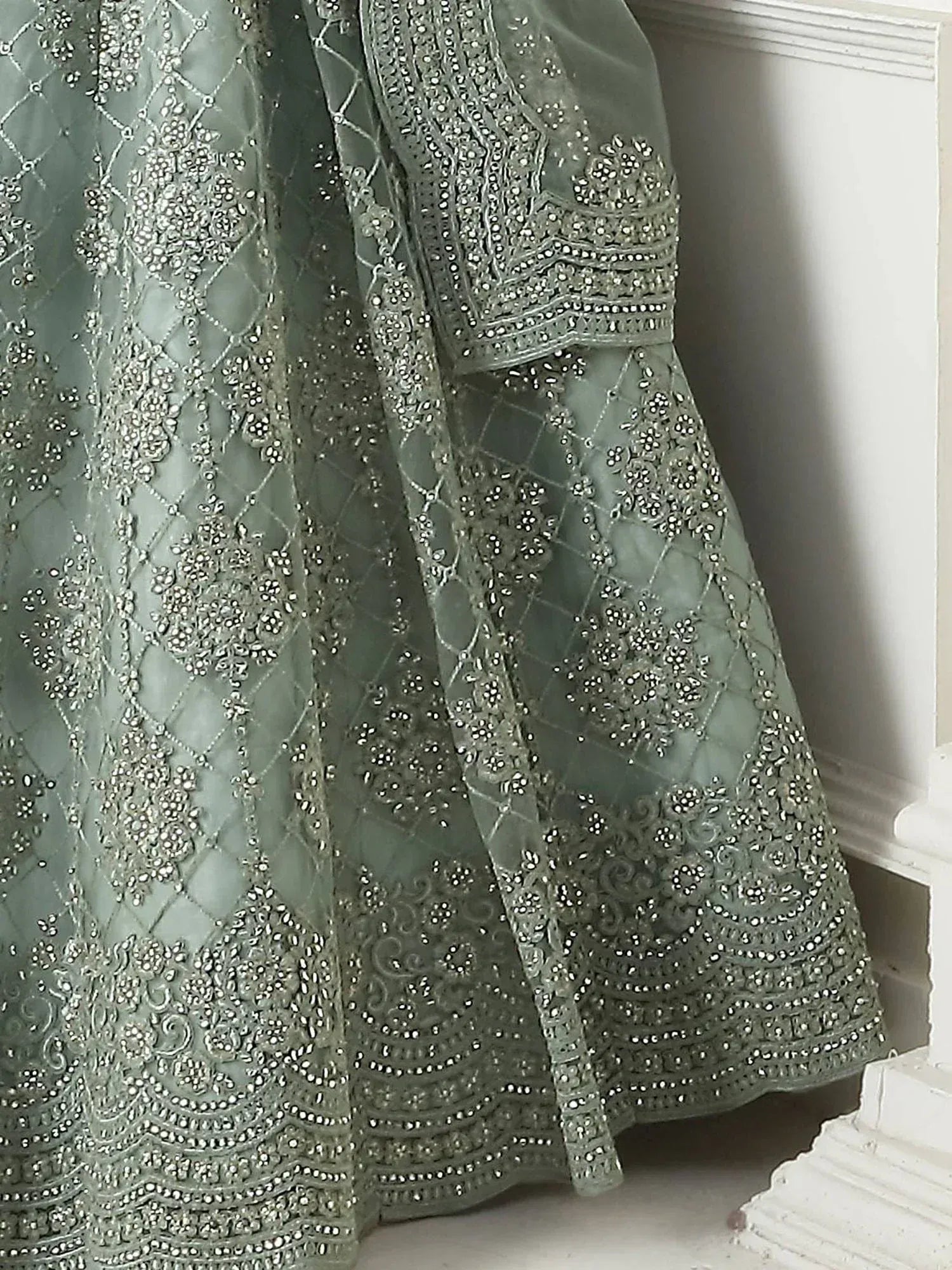 Sage green designer lehenga with intricate silver embroidery and beadwork, perfect for Indian ethnic wear.