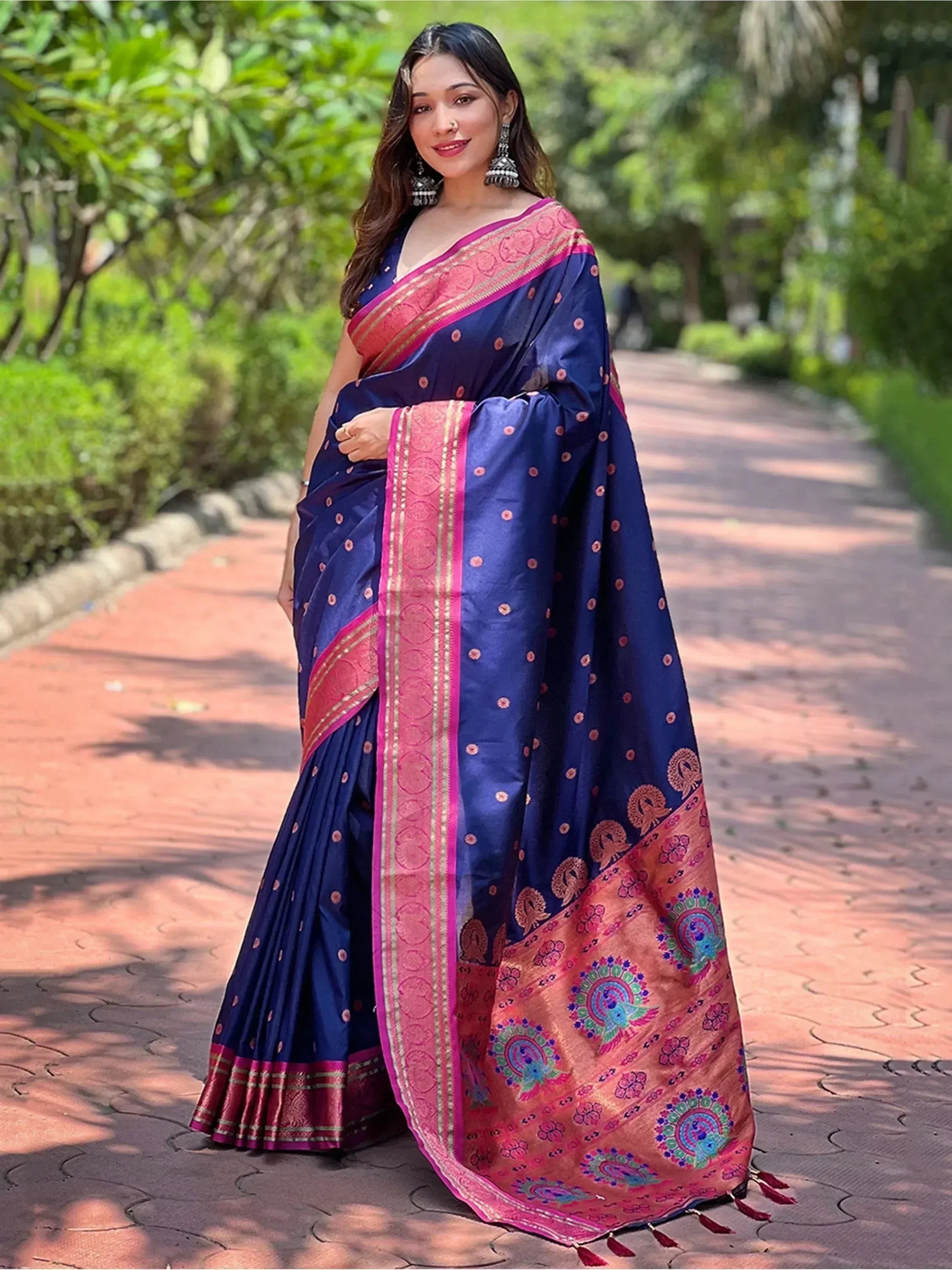 Woman in navy blue silk saree with pink border and peacock motifs, perfect for Indian ethnic occasions