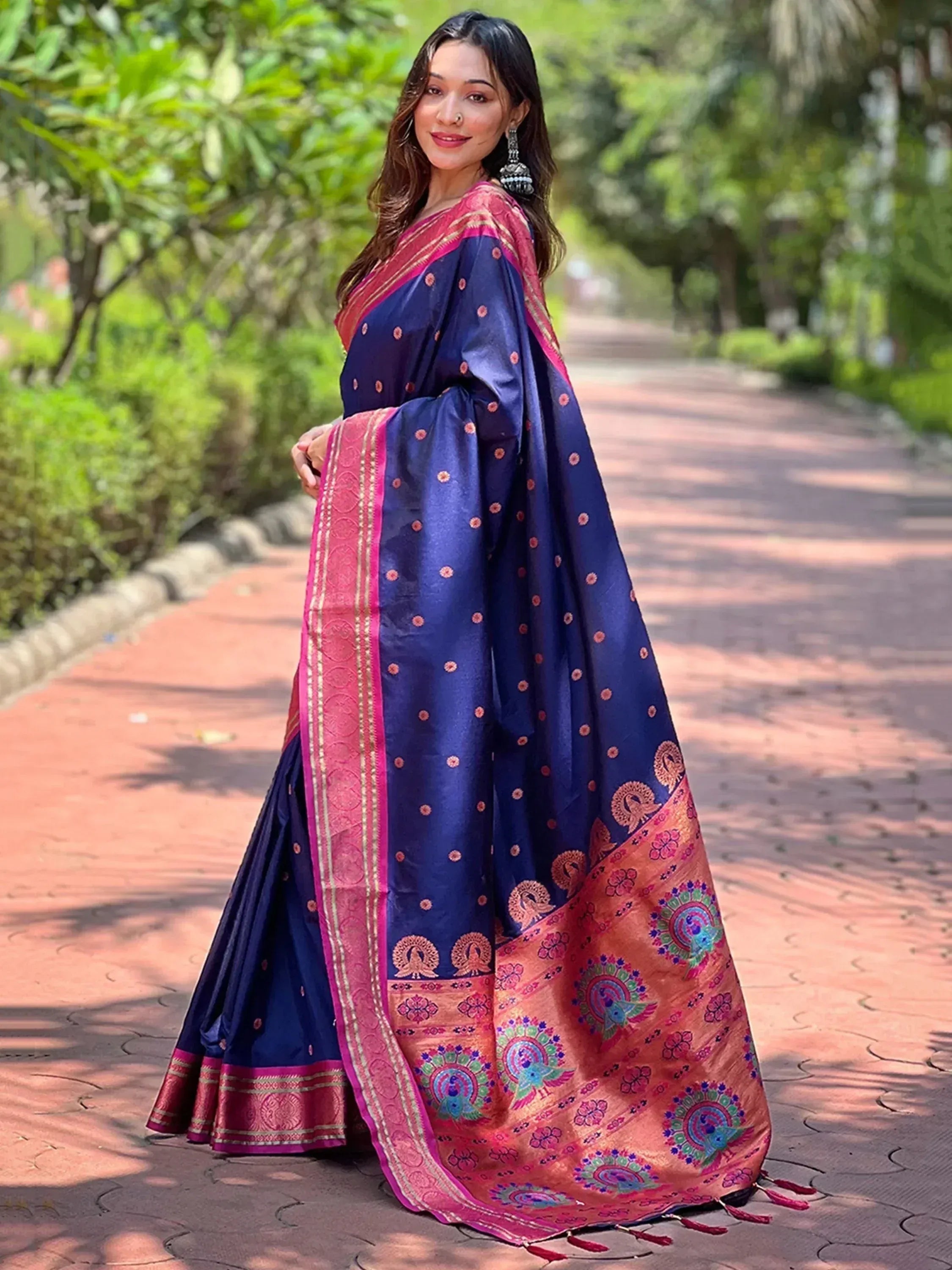 Woman in navy blue saree with pink border and peacock motifs, perfect for Indian ethnic occasions