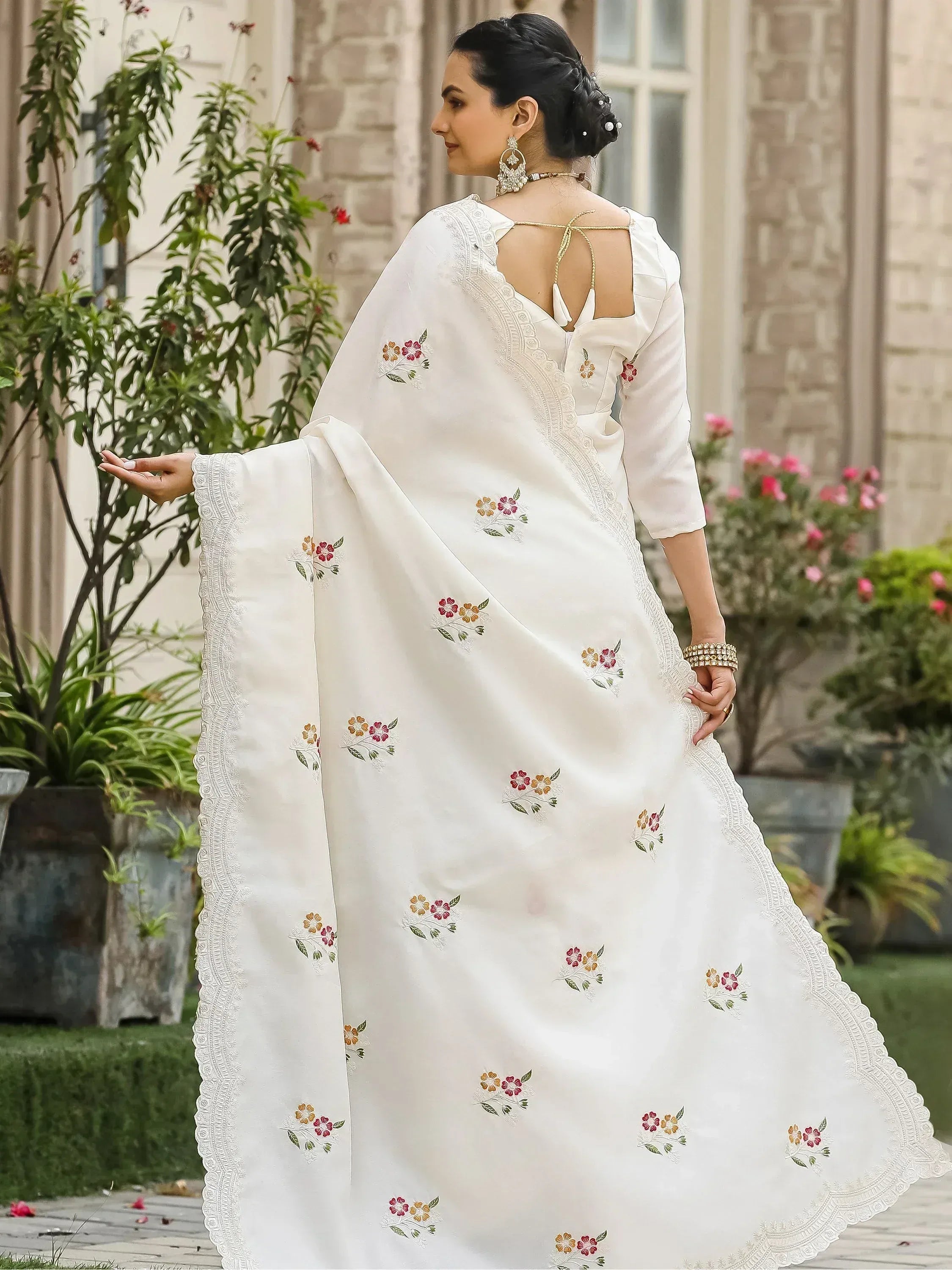 White embroidered saree with floral motifs and lace border, perfect for ethnic occasions