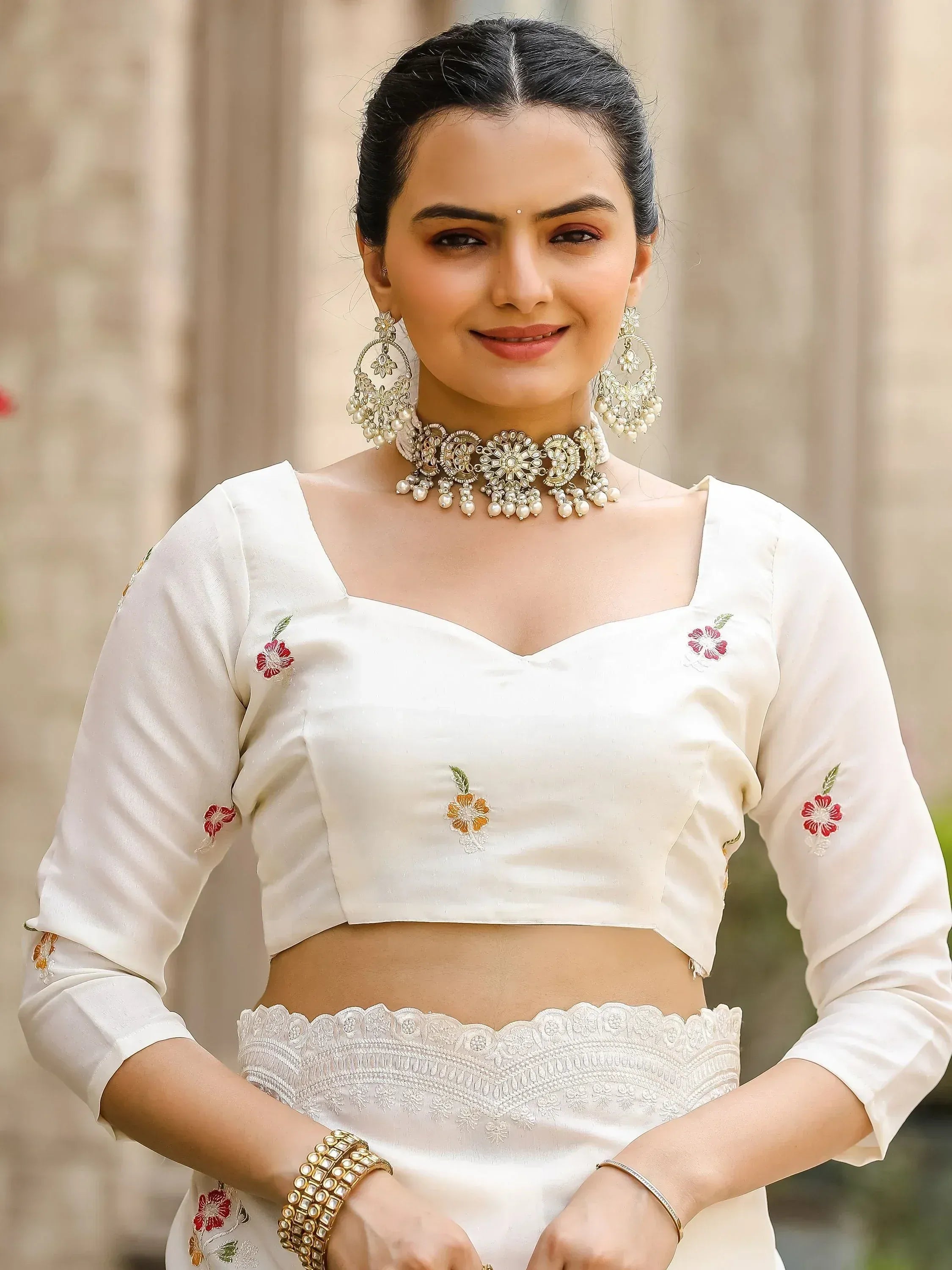White embroidered crop top with floral details, paired with lace waistband, perfect for Indian ethnic wear