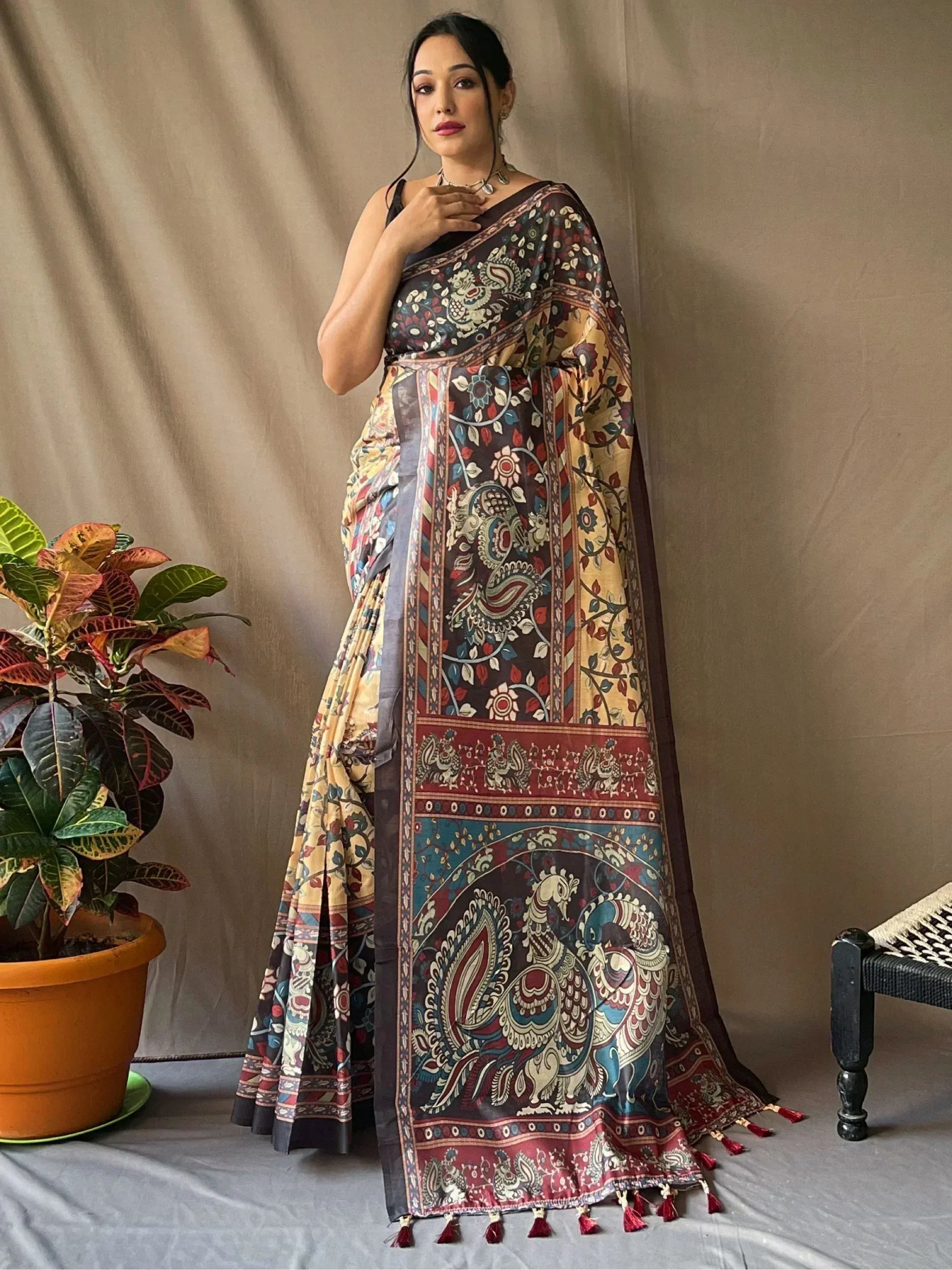 Woman in designer printed saree with peacock motifs, tassels, and ethnic border for Indian wear