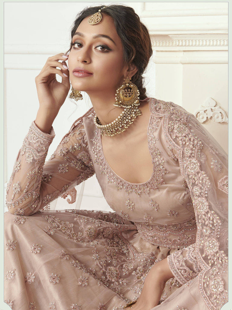 Elegant blush pink embroidered lehenga choli with gold jewelry, perfect for Indian weddings and festive occasions.