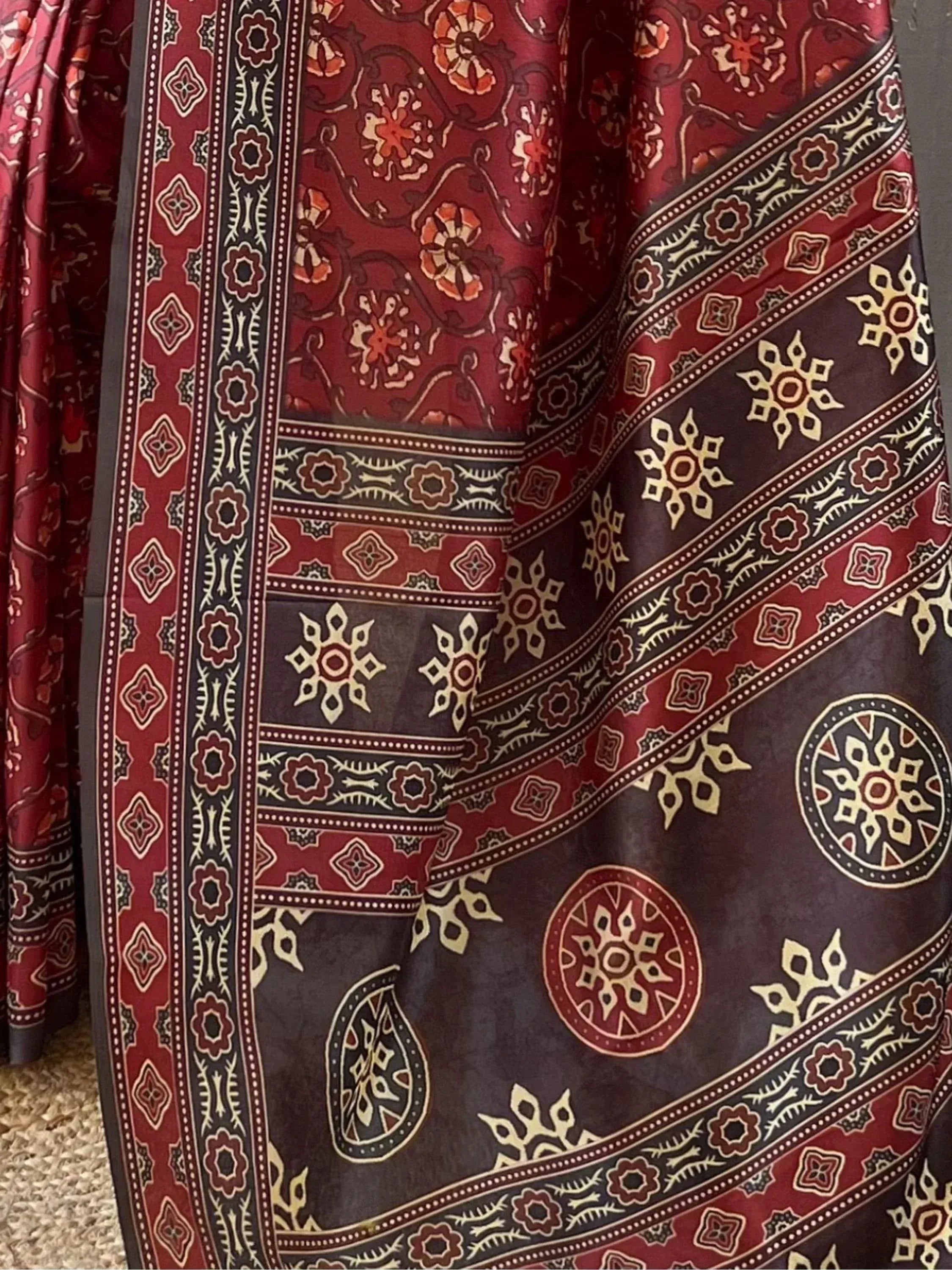 Rich maroon ethnic saree with intricate floral and geometric prints, perfect for traditional Indian wear.