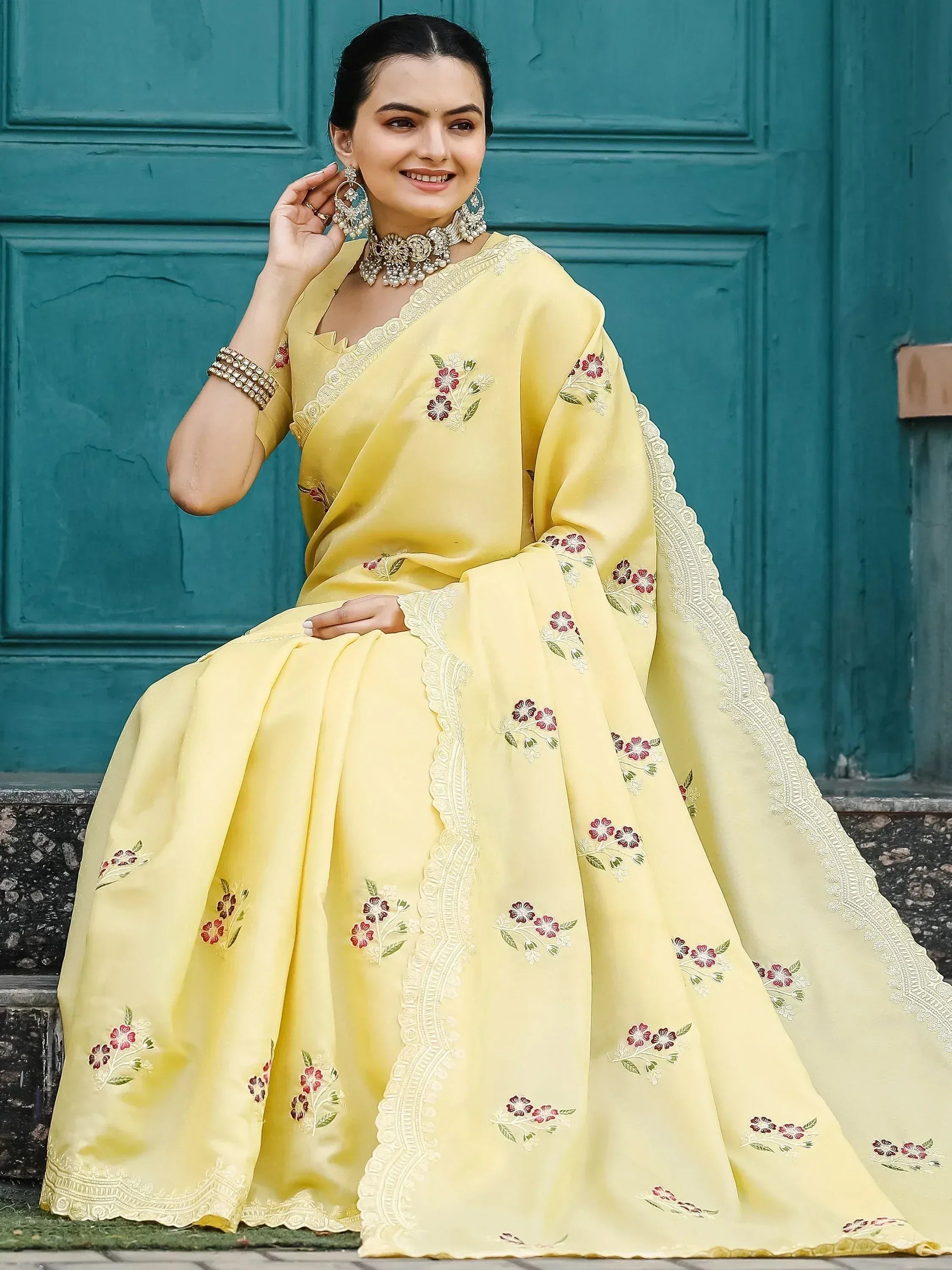 Yellow floral embroidered saree with lace border, styled with traditional jewelry for Indian ethnic wear