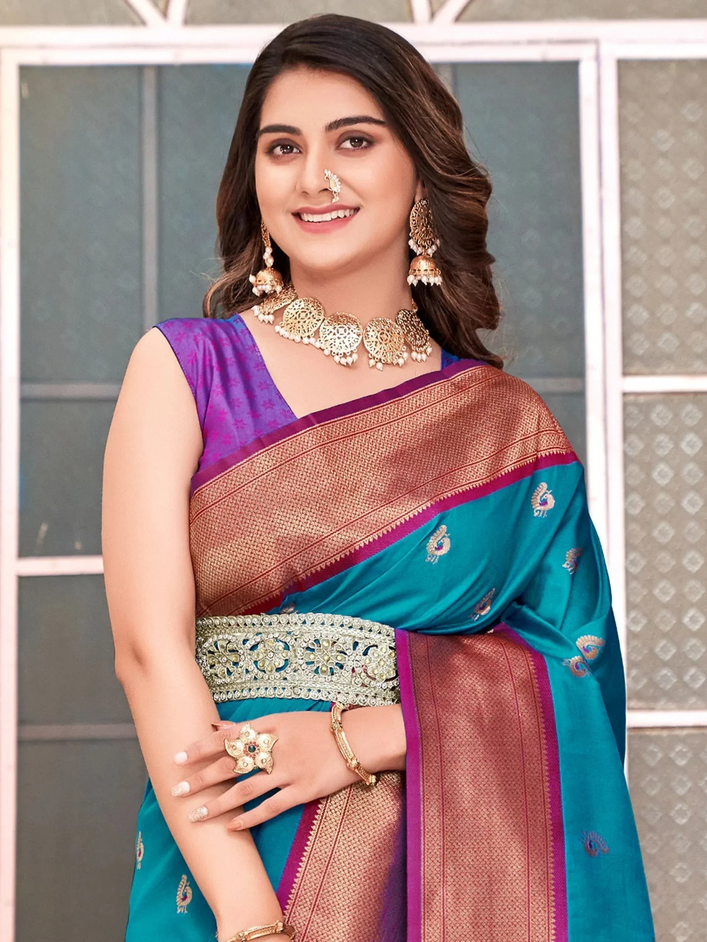 Woman in teal and purple designer saree with gold embroidery, traditional Indian ethnic wear