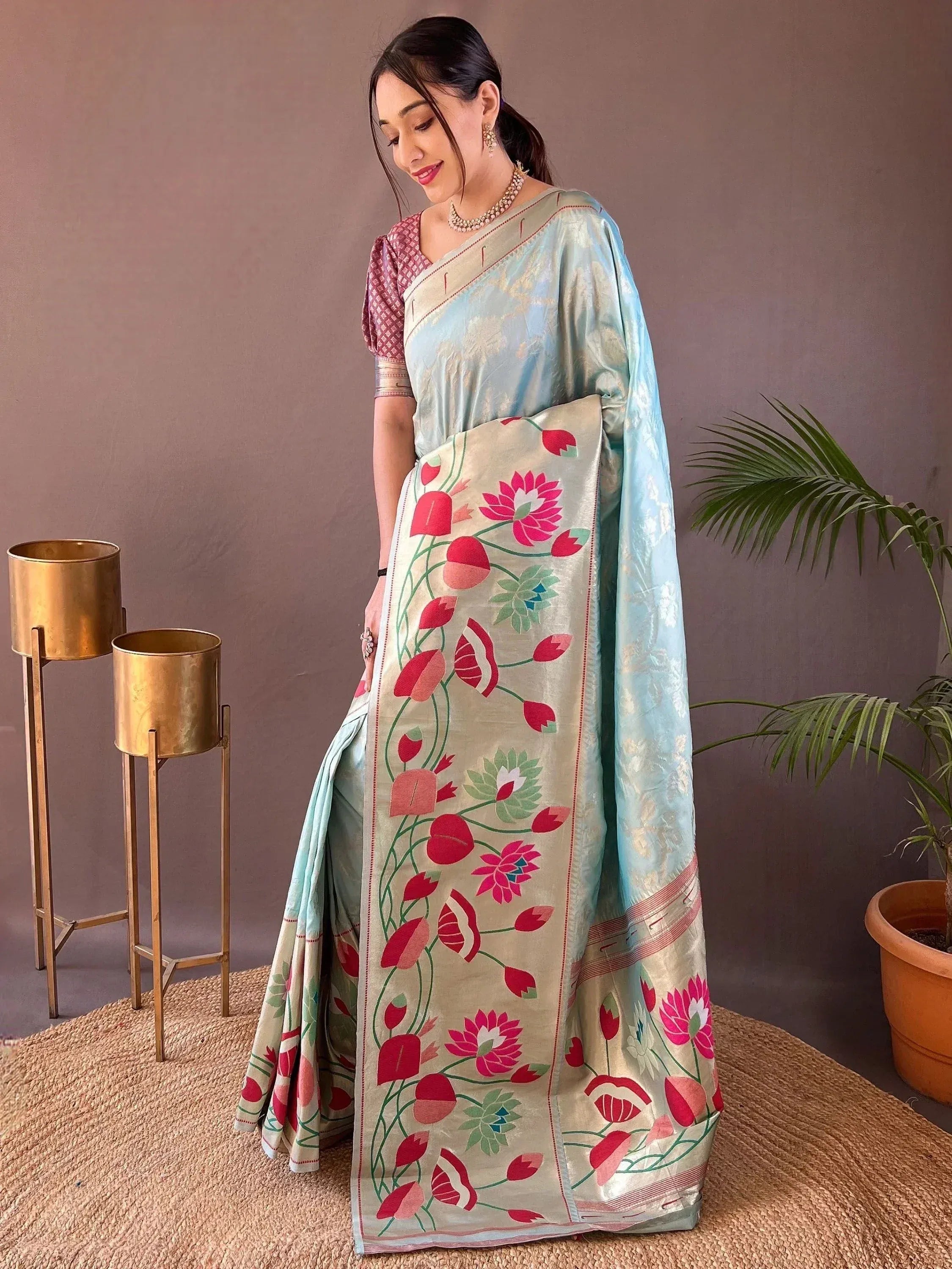 Elegant light blue saree with floral embroidery, paired with a maroon blouse, perfect for Indian ethnic occasions.