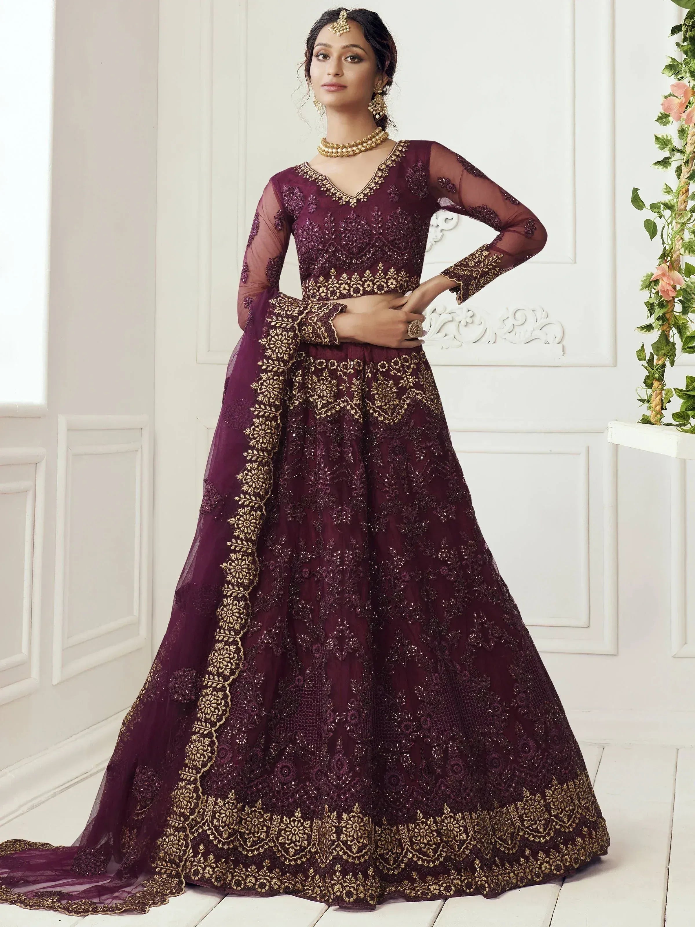 Elegant maroon lehenga choli with gold embroidery, perfect for Indian weddings and festive occasions.