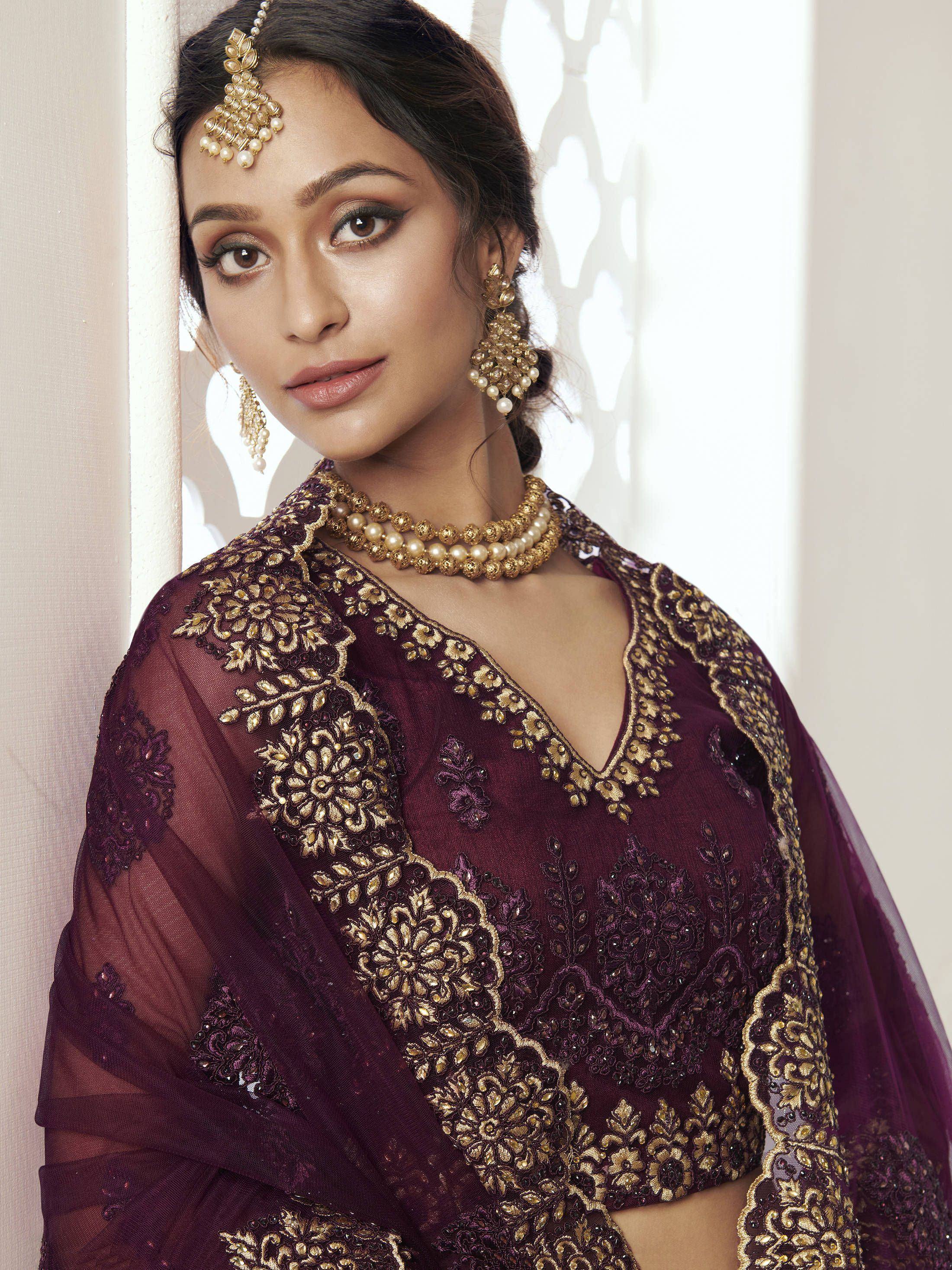 Elegant maroon ethnic gown with gold embroidery, perfect for Indian weddings and festive occasions.