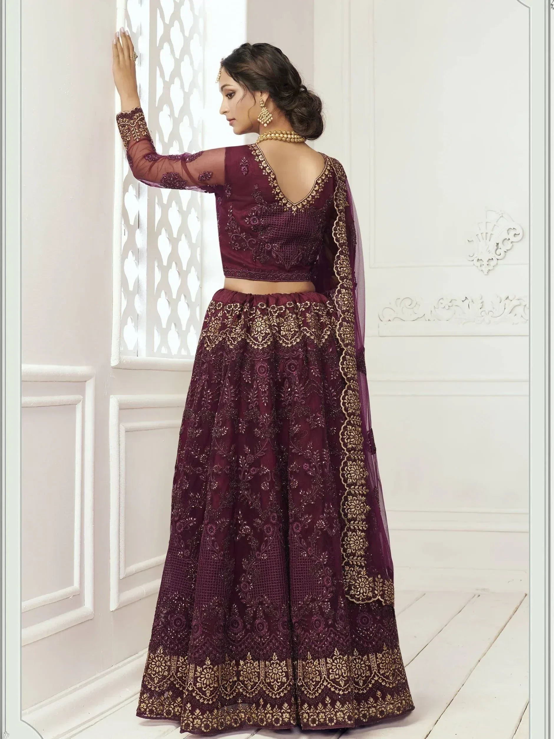 Elegant maroon lehenga choli with gold embroidery, perfect for Indian weddings and festive occasions.