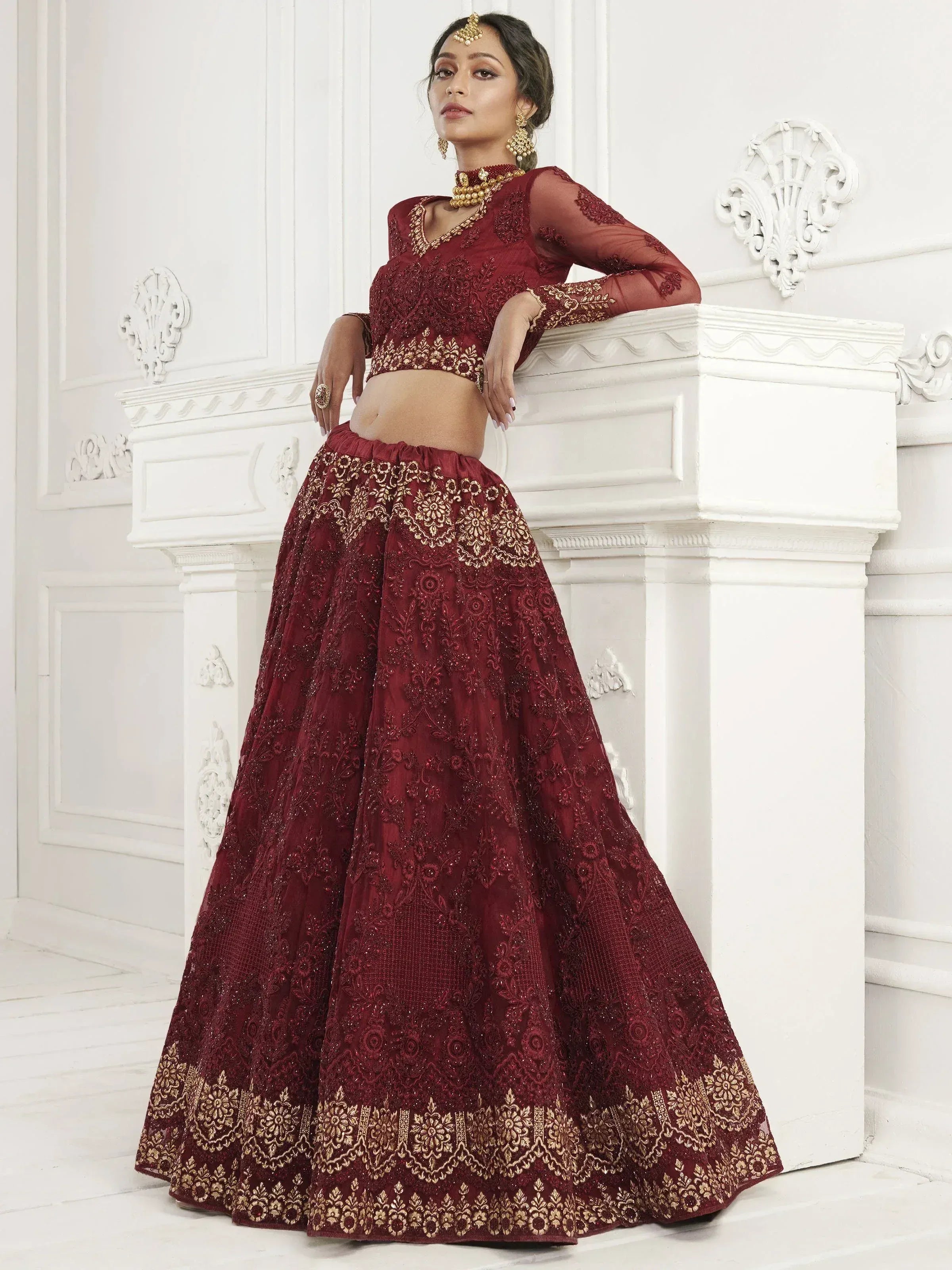 Burgundy embroidered lehenga choli with gold detailing, perfect for Indian weddings and festive occasions.