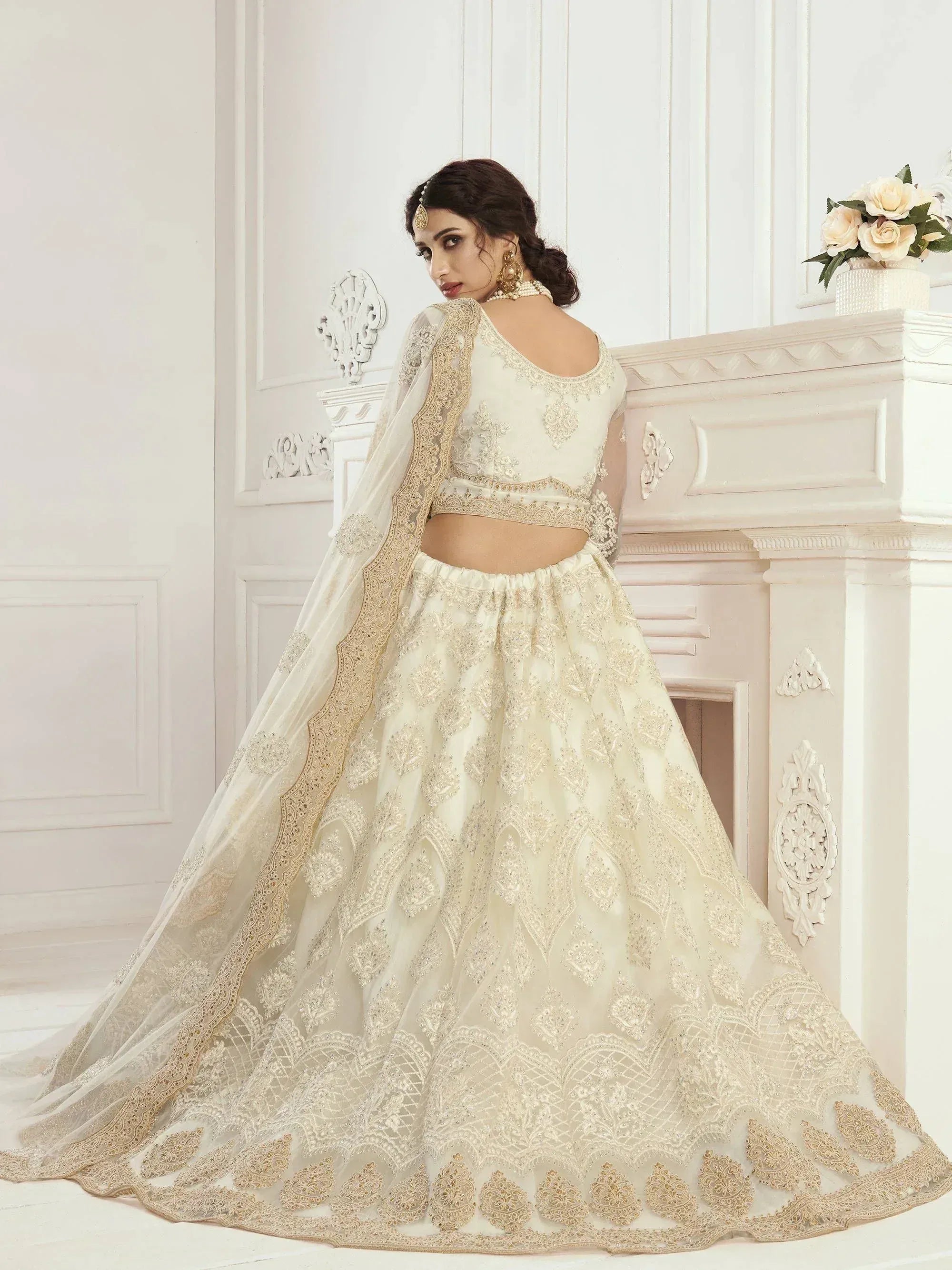 Elegant ivory lehenga choli with gold embroidery, perfect for weddings and festive occasions.