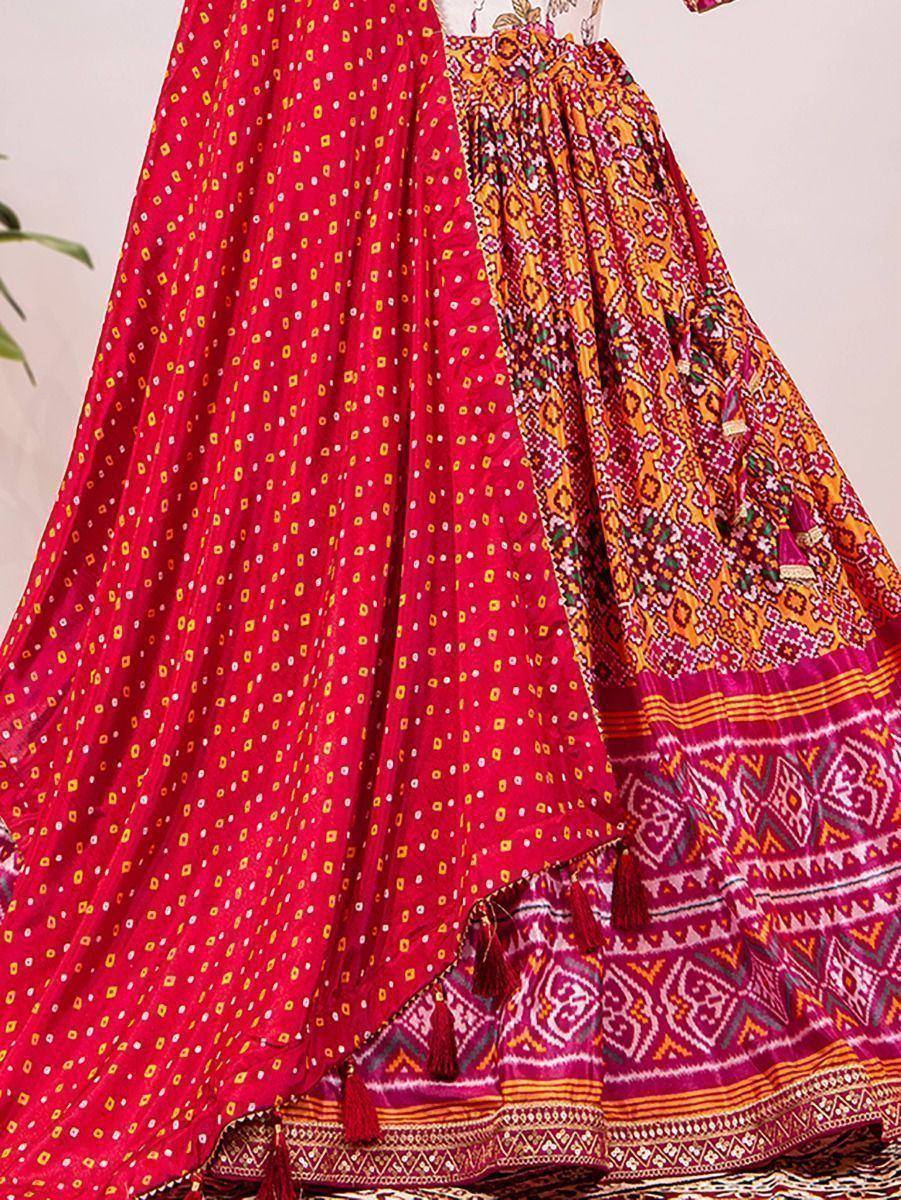 Vibrant red and orange printed lehenga choli with tassels, perfect for Indian ethnic wear occasions