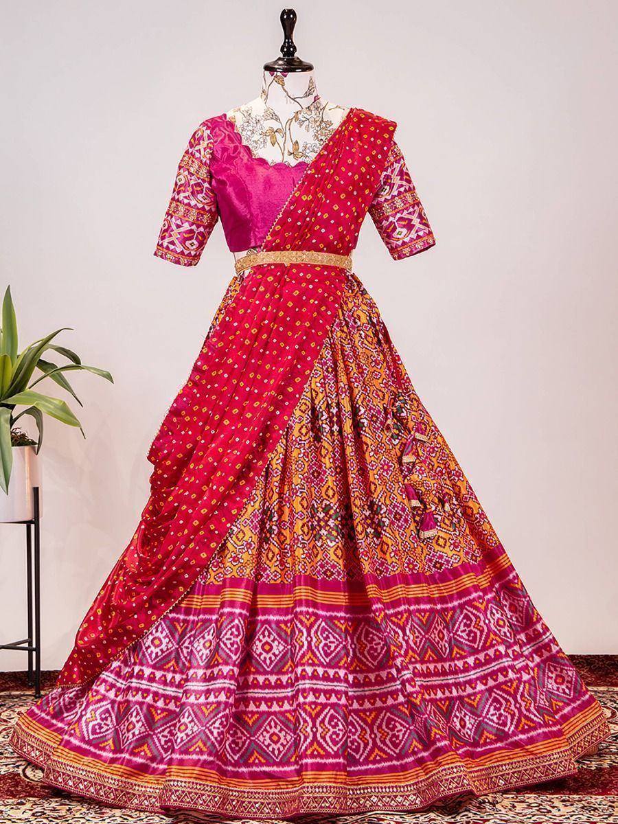 Vibrant pink and orange printed lehenga choli with ethnic patterns, perfect for Indian weddings and festivals.