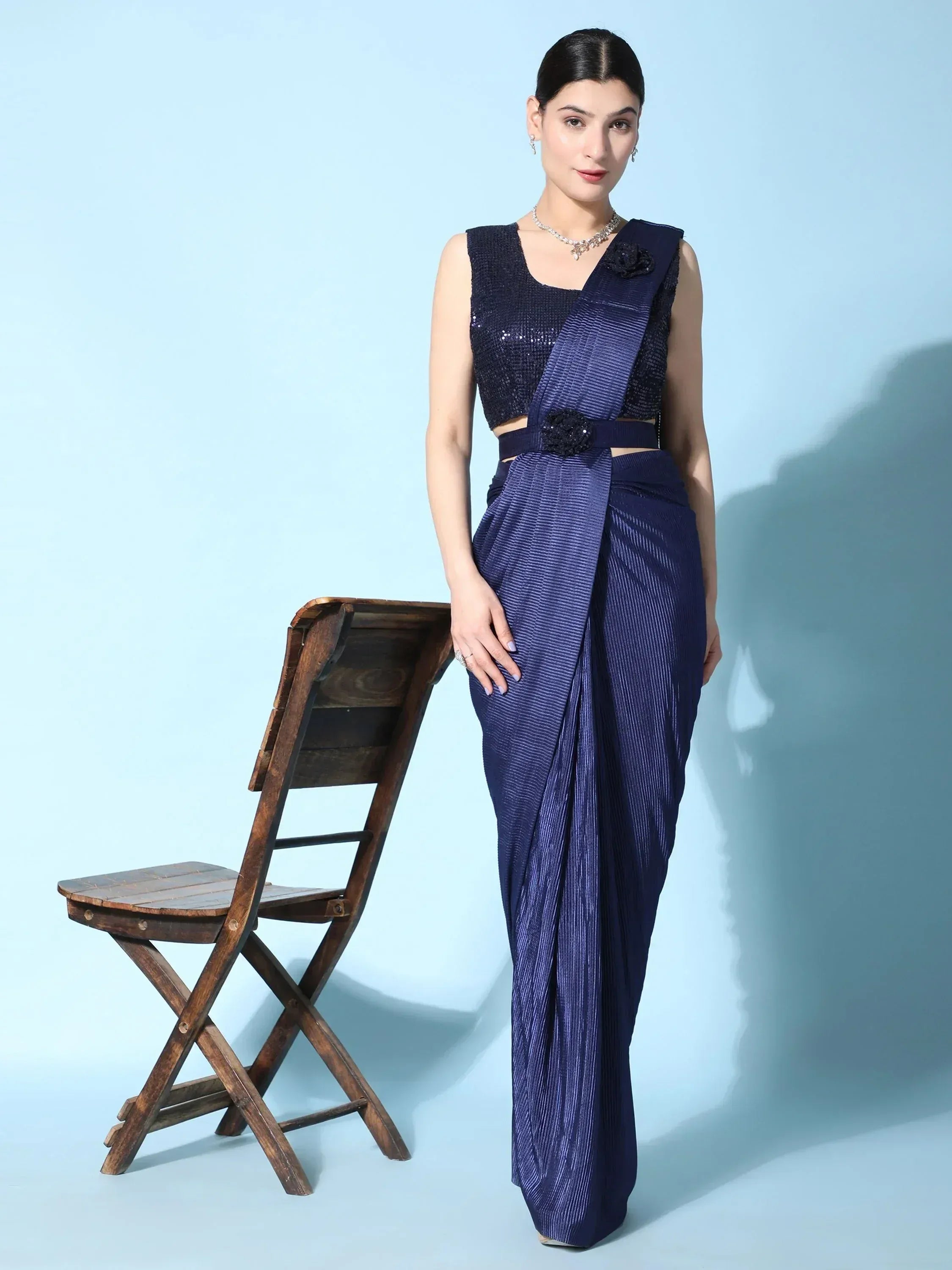 Elegant navy blue ethnic saree with sequined blouse and floral belt, styled for modern Indian fashion.