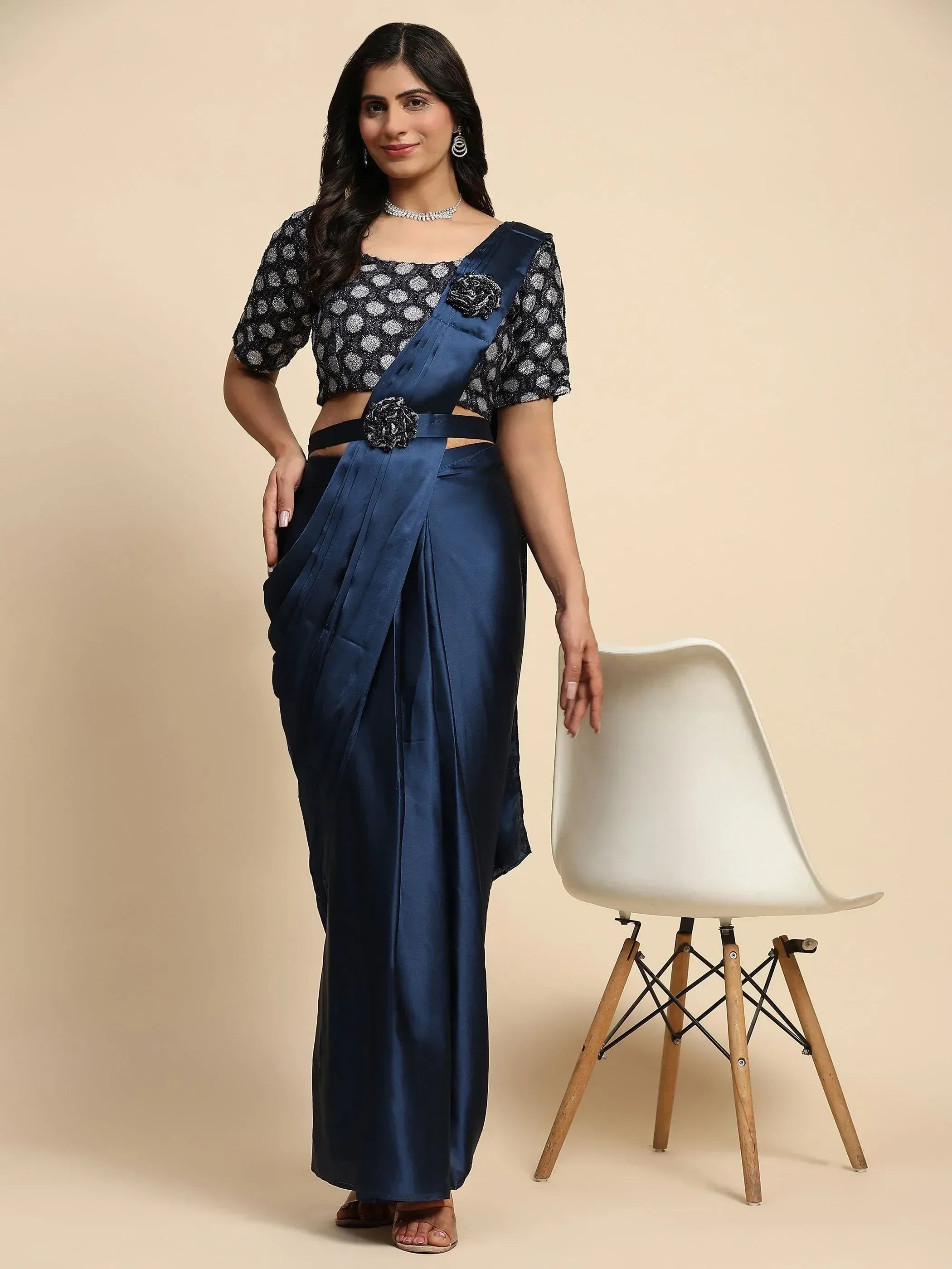Navy blue satin saree with polka dot blouse, floral embellishments, and modern drape for ethnic wear