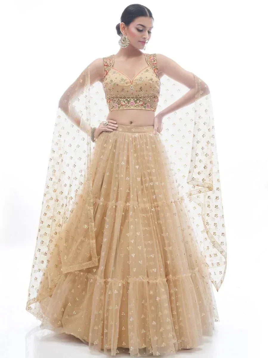 Elegant gold embroidered lehenga choli with floral motifs and sheer dupatta, perfect for Indian weddings and festive occasions.