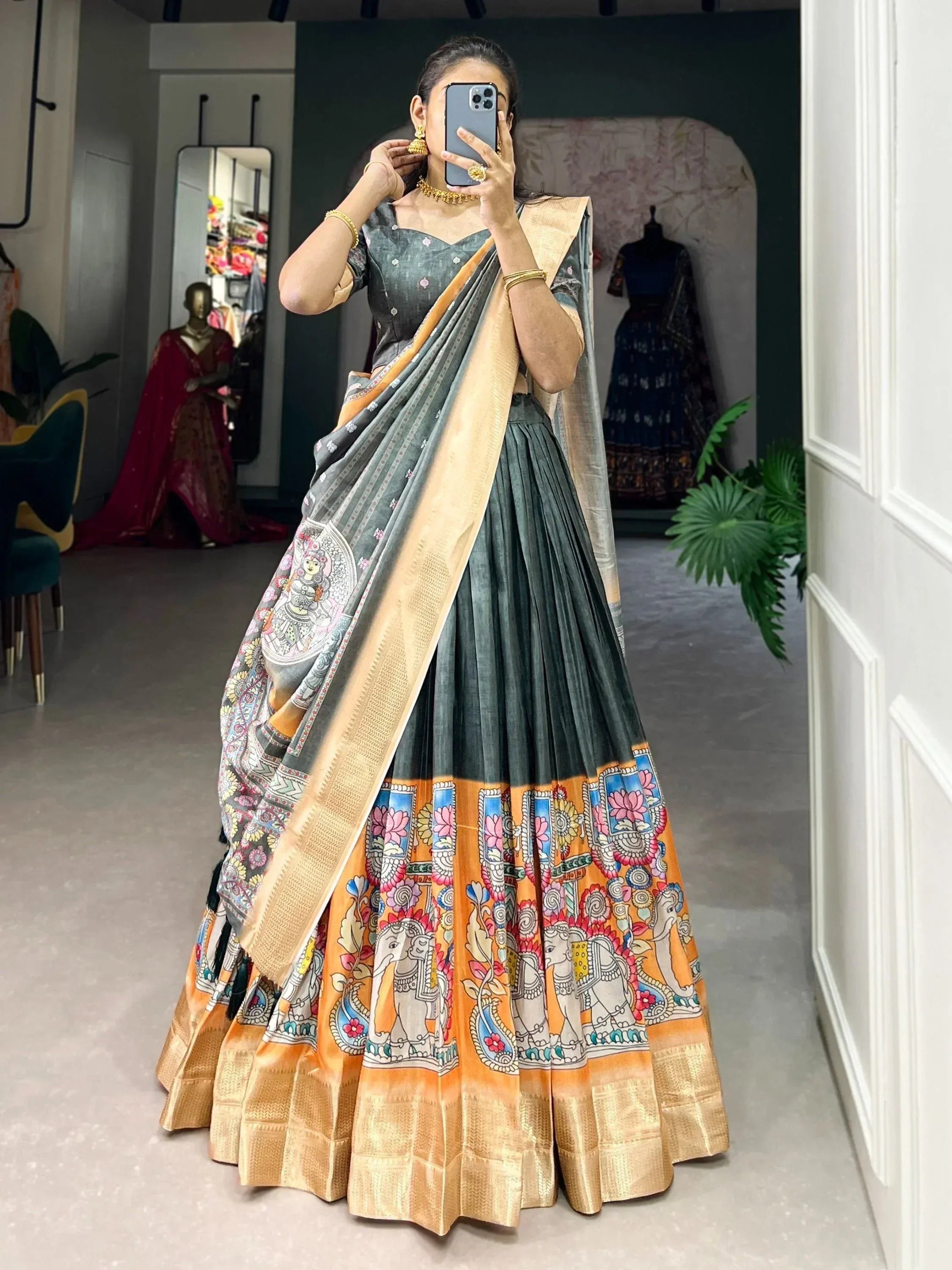 Woman in grey and orange printed lehenga choli with elephant motifs, traditional Indian ethnic wear