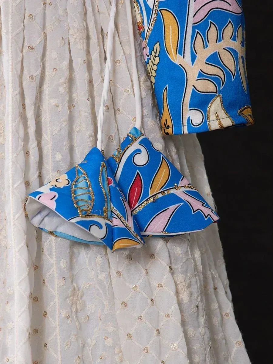 Blue floral printed ethnic blouse with gold trim, paired with white embroidered skirt