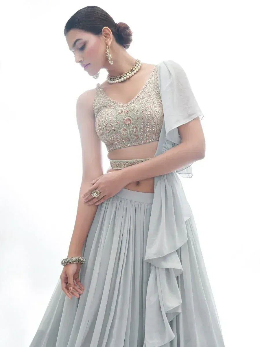 Elegant light grey lehenga choli with embroidered blouse and ruffled dupatta, perfect for Indian ethnic occasions.