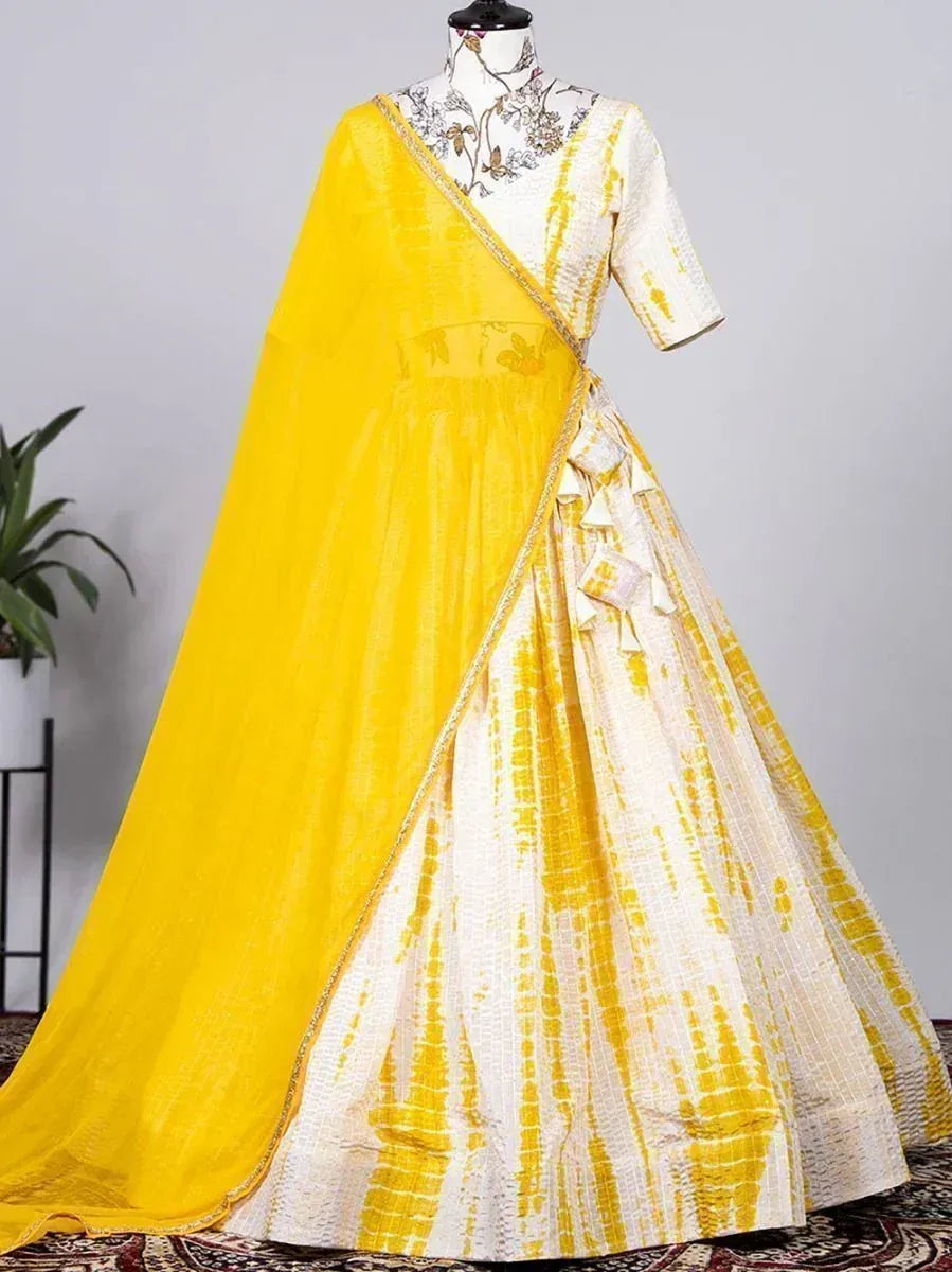 Yellow and white tie-dye lehenga choli with floral embroidery and matching dupatta, perfect for Indian ethnic wear.