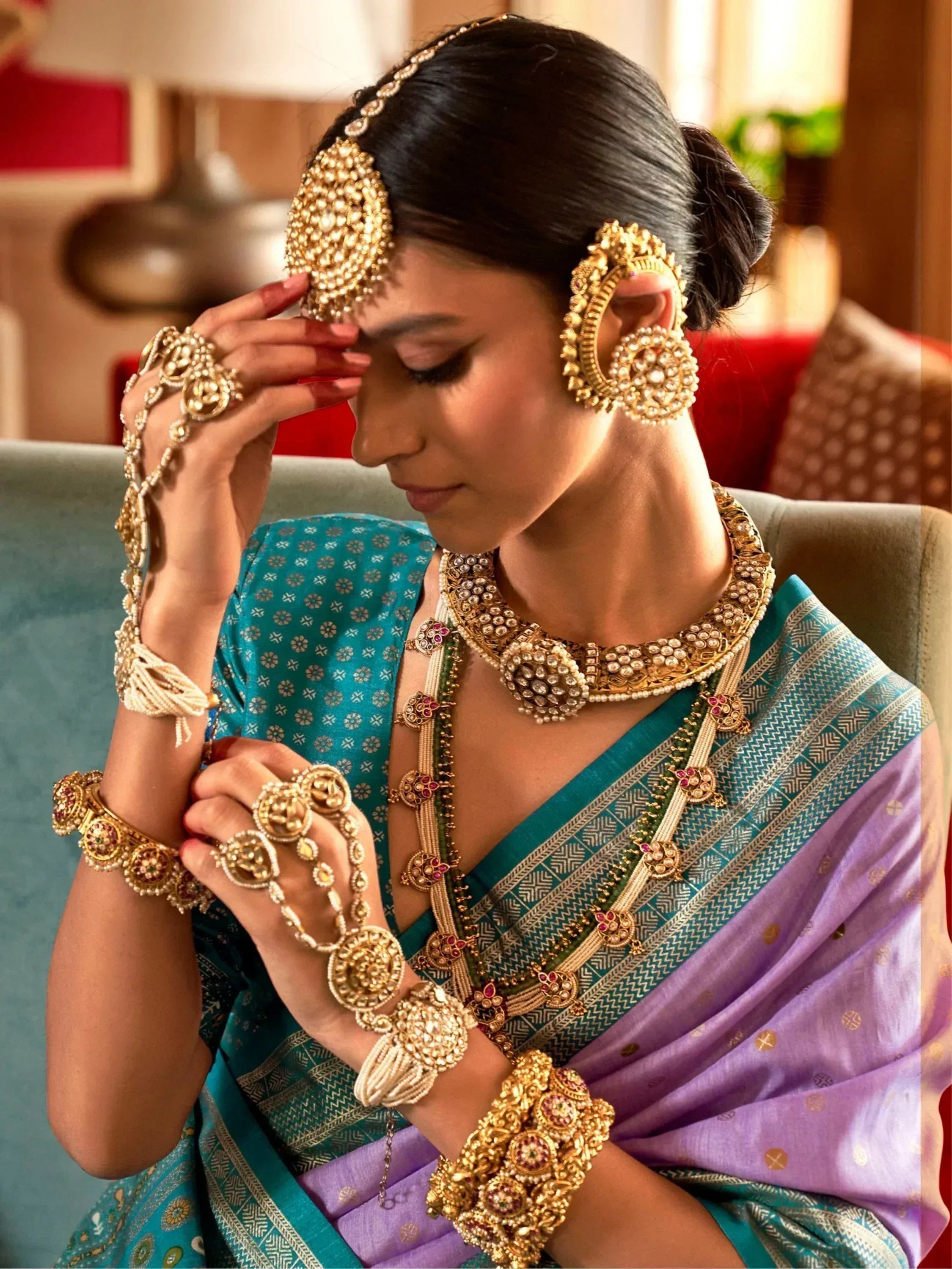 Woman in teal and lavender saree with heavy gold temple jewelry, perfect for Indian ethnic occasions.
