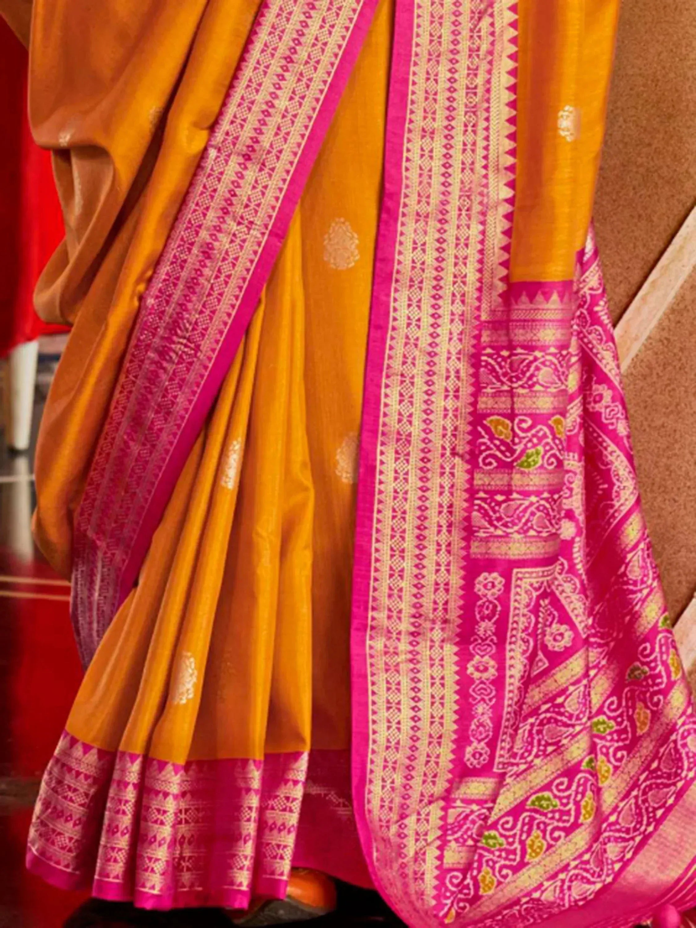Vibrant yellow and pink ethnic saree with intricate woven border and traditional motifs, perfect for festive occasions.