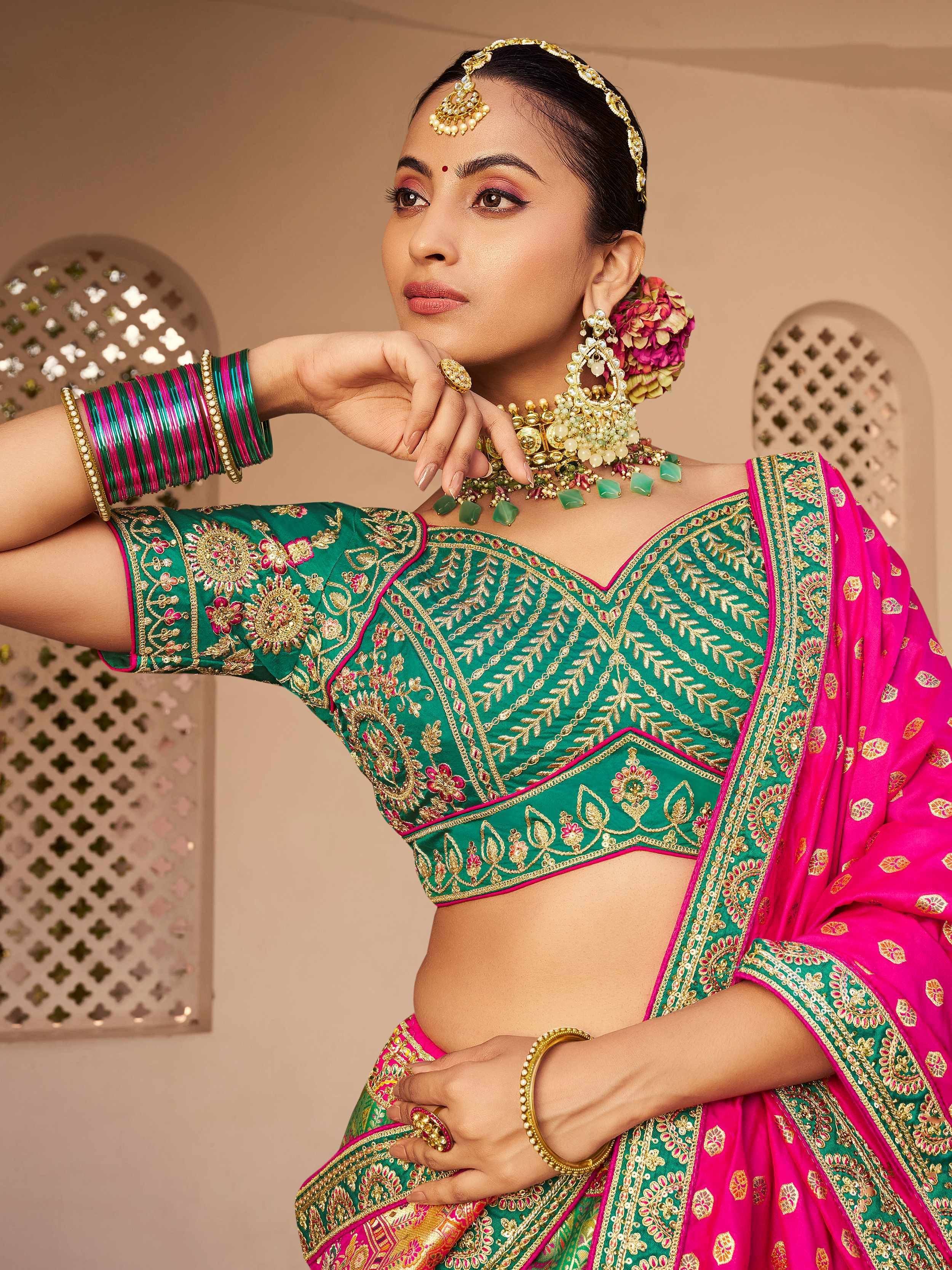 Green and pink embroidered lehenga choli with gold jewelry, perfect for Indian ethnic wear occasions