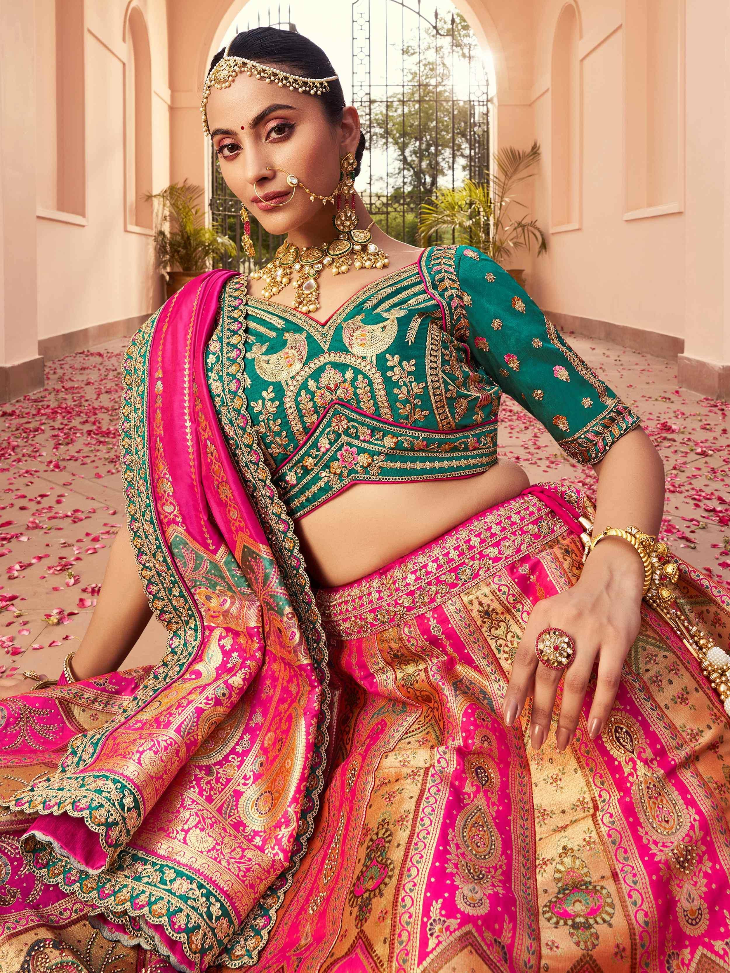 Emerald green and pink embroidered lehenga choli with gold jewelry, perfect for Indian weddings and festivals