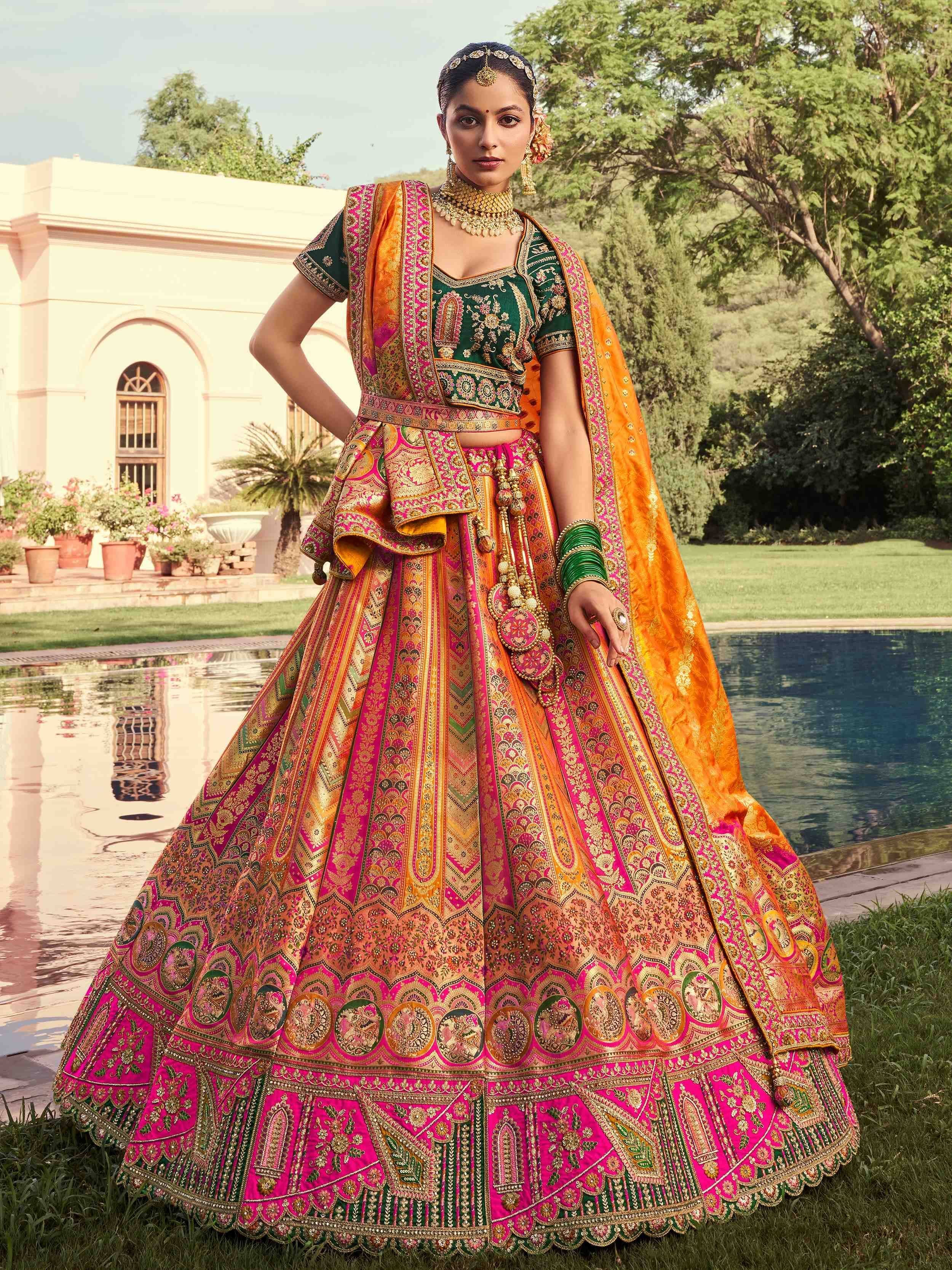 Designer lehenga choli in vibrant pink, green, and orange with intricate embroidery, perfect for Indian weddings and festive occasions.