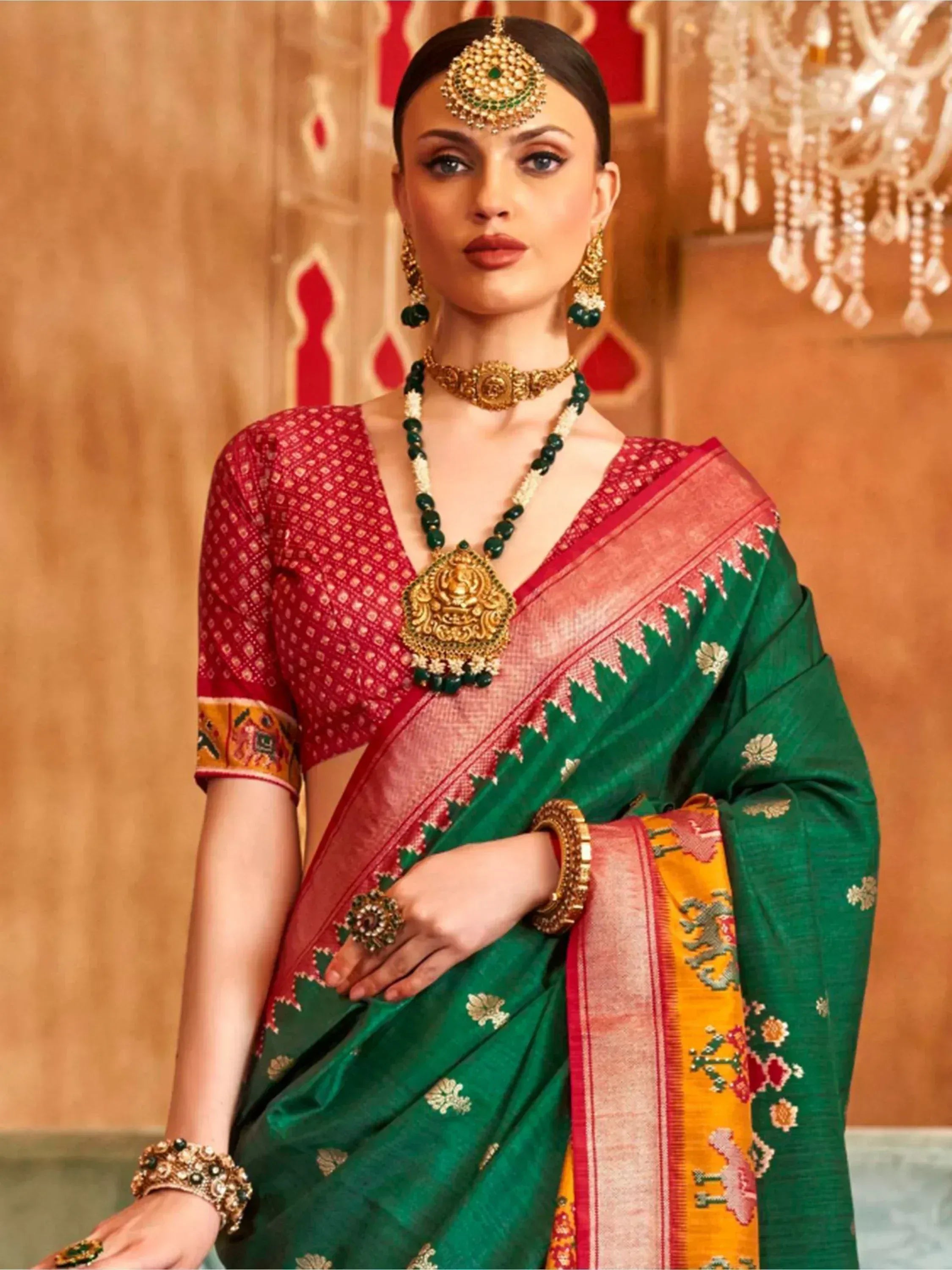 Green and red ethnic saree with gold jewelry, perfect for Indian weddings and festive occasions