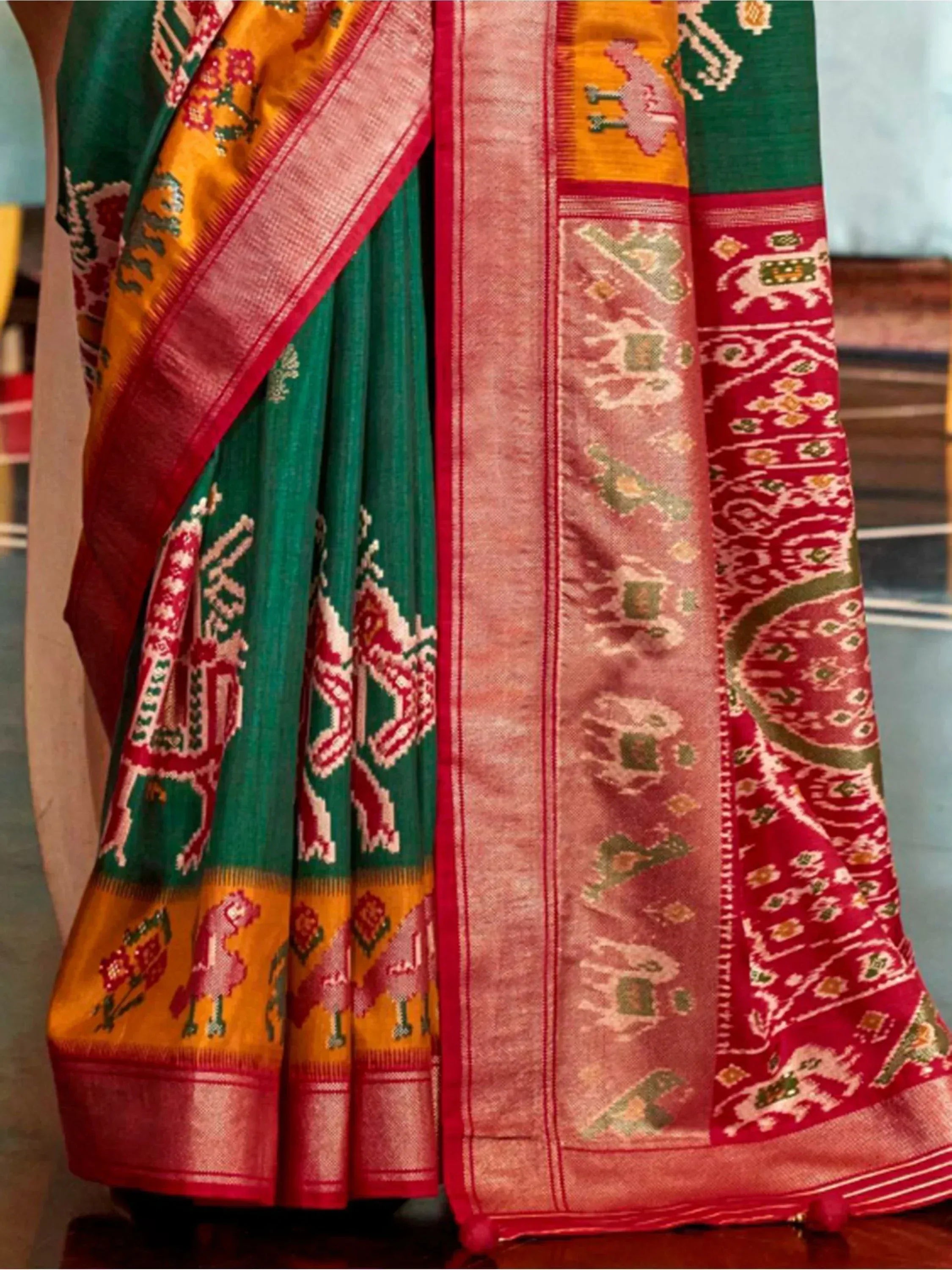 Green and red ethnic saree with elephant motifs and gold border, traditional Indian designer wear