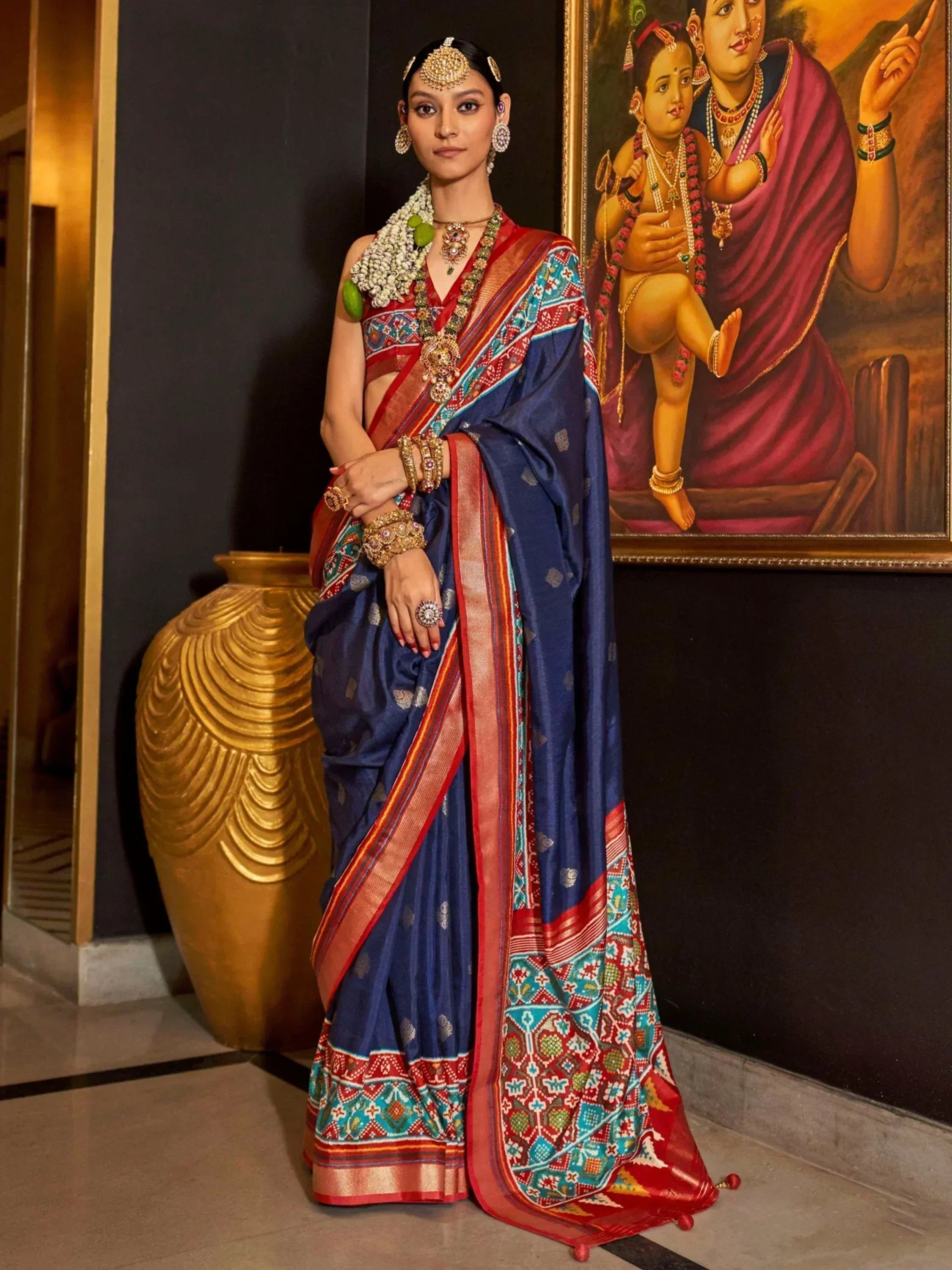 Woman in traditional Indian saree with intricate embroidery and temple jewelry, styled for festive occasions.