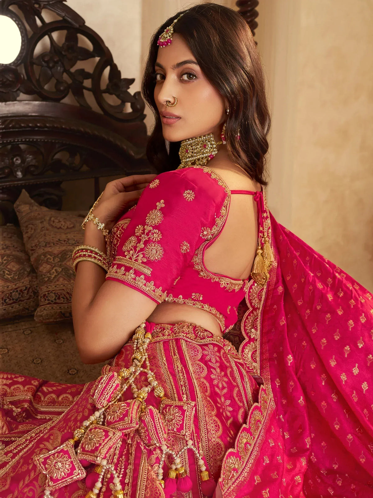 Pink designer lehenga choli with gold embroidery, perfect for Indian weddings and festive occasions.