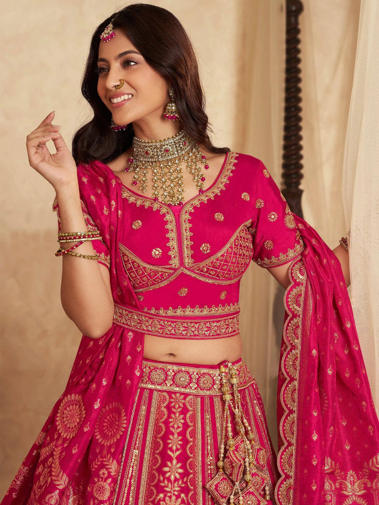 Pink designer lehenga choli with gold embroidery, perfect for Indian weddings and festive occasions.