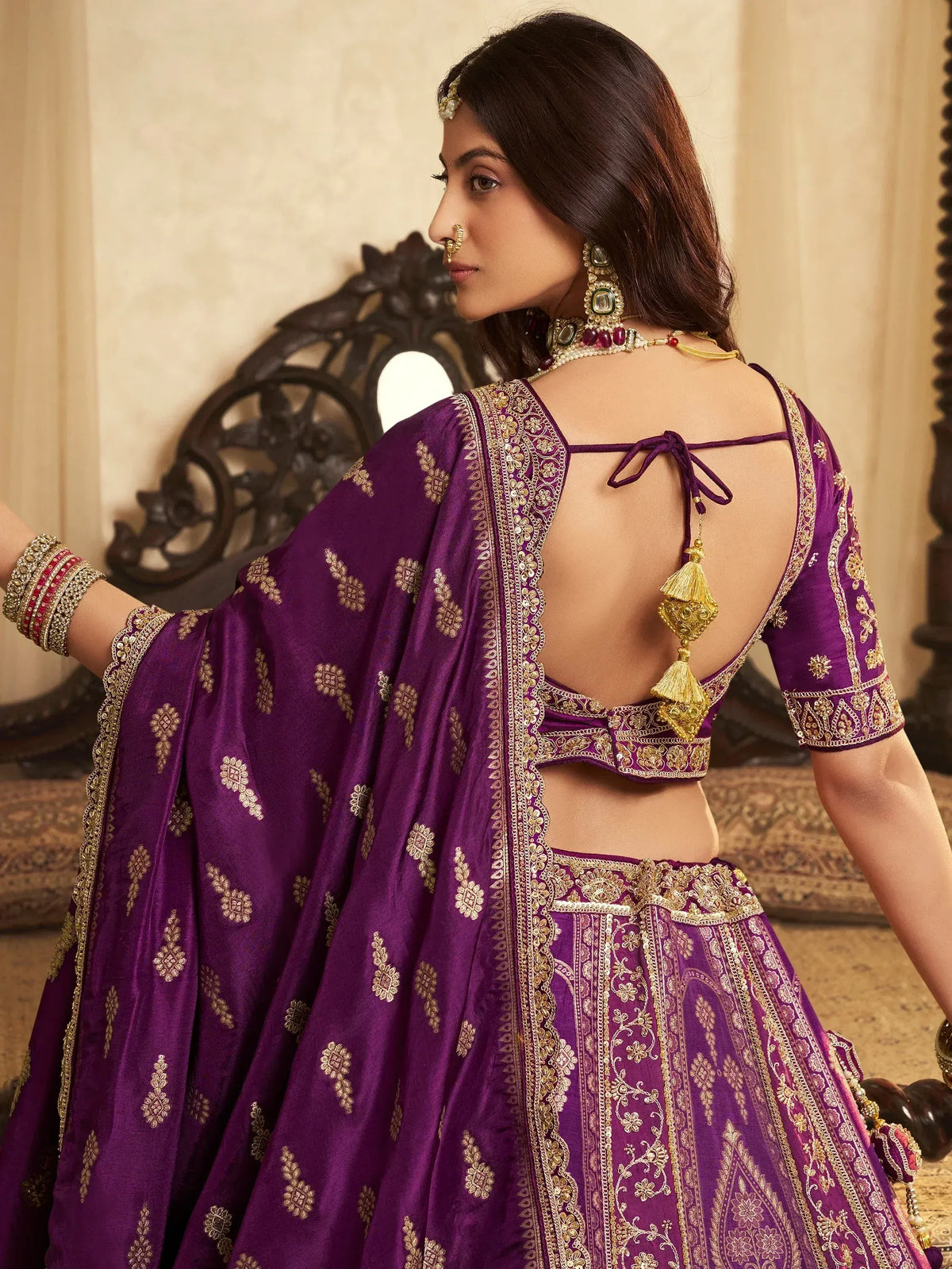 Purple designer lehenga choli with gold embroidery and back tie detail, perfect for Indian ethnic wear.