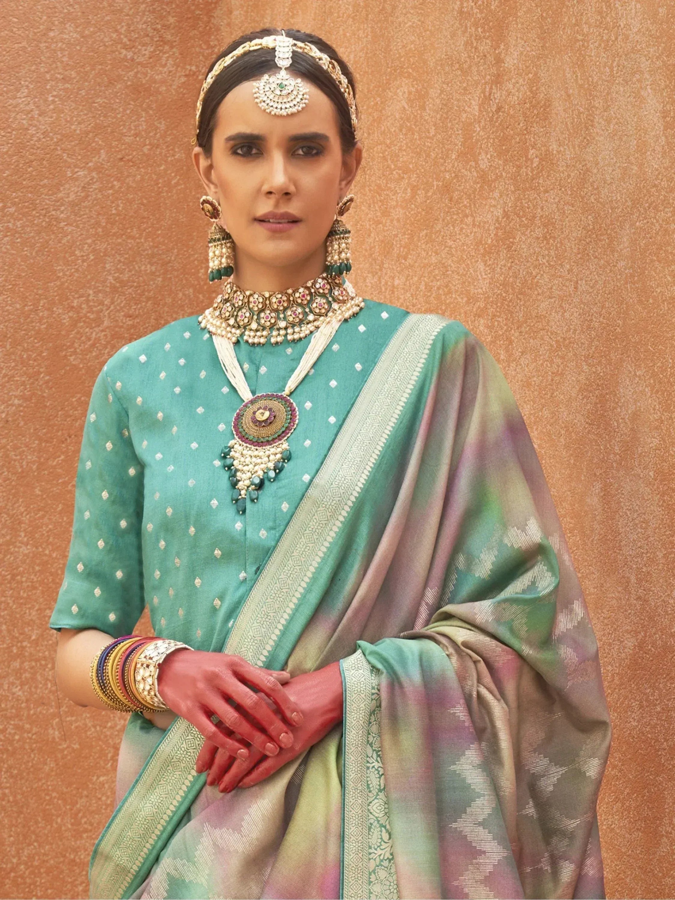 Woman in teal ethnic saree with gold jewelry, traditional Indian attire for festive occasions