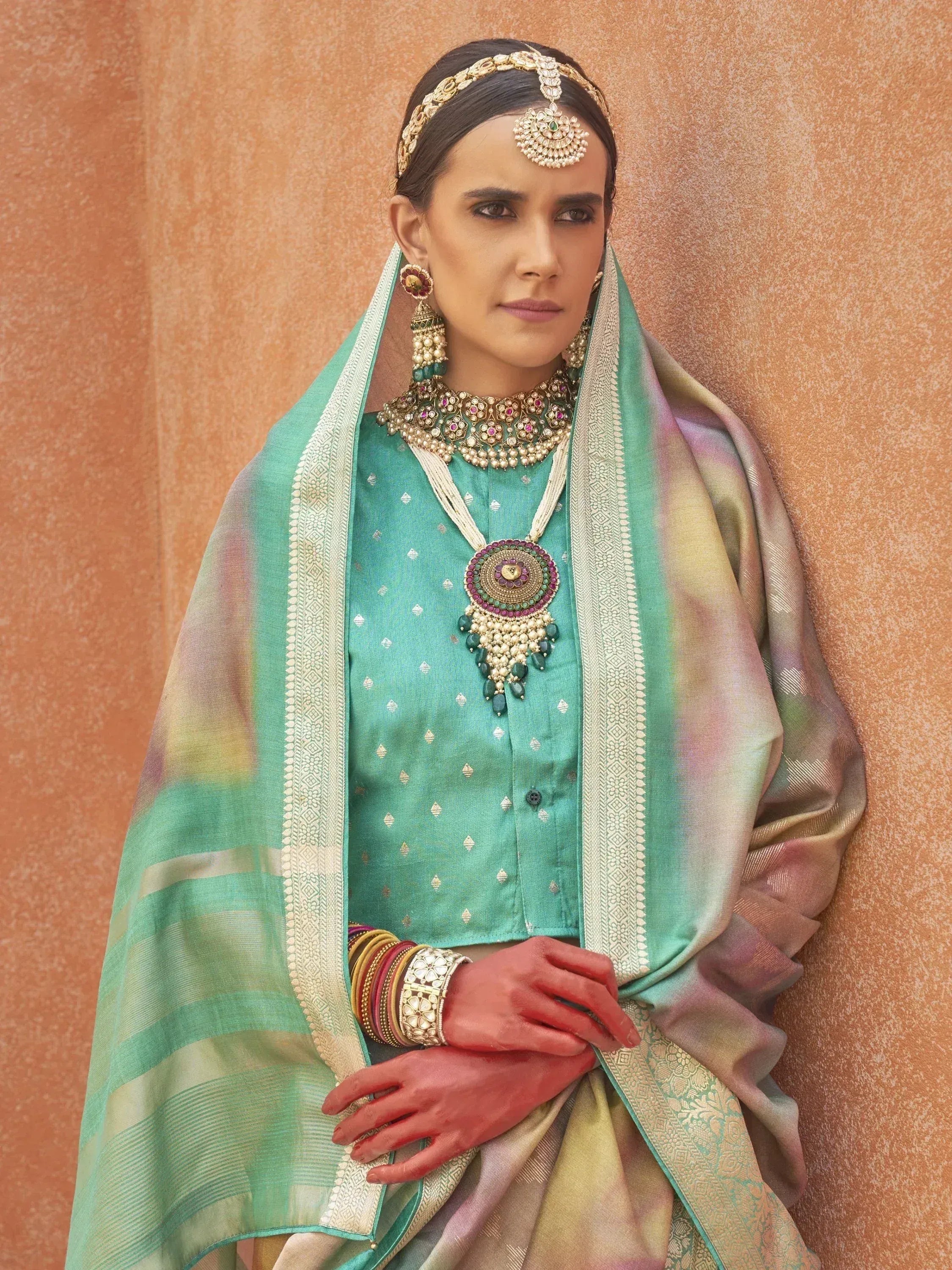 Woman in teal Indian ethnic wear with ornate jewelry and dupatta, perfect for weddings or festivals